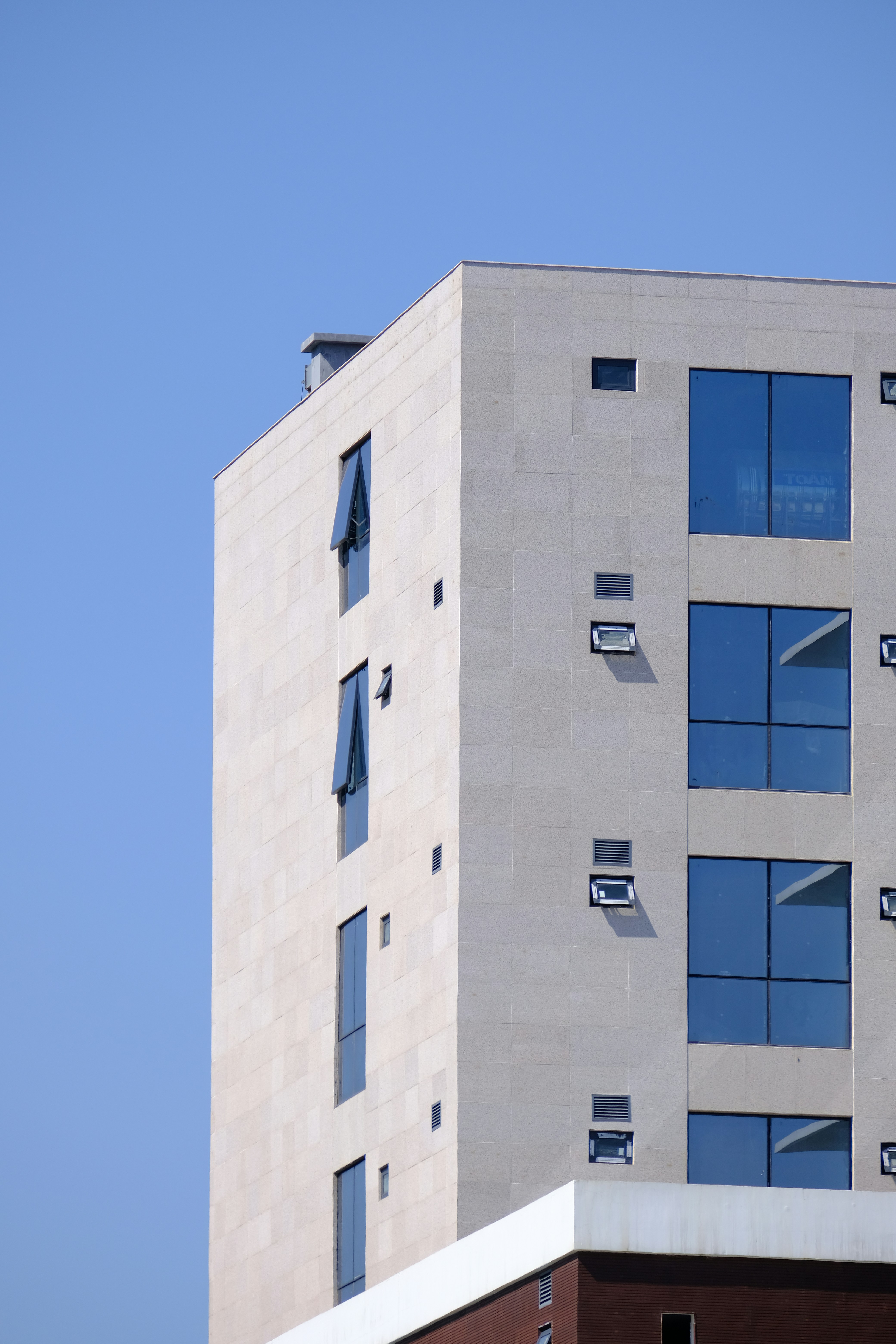 Modern building with blue windows against clear sky