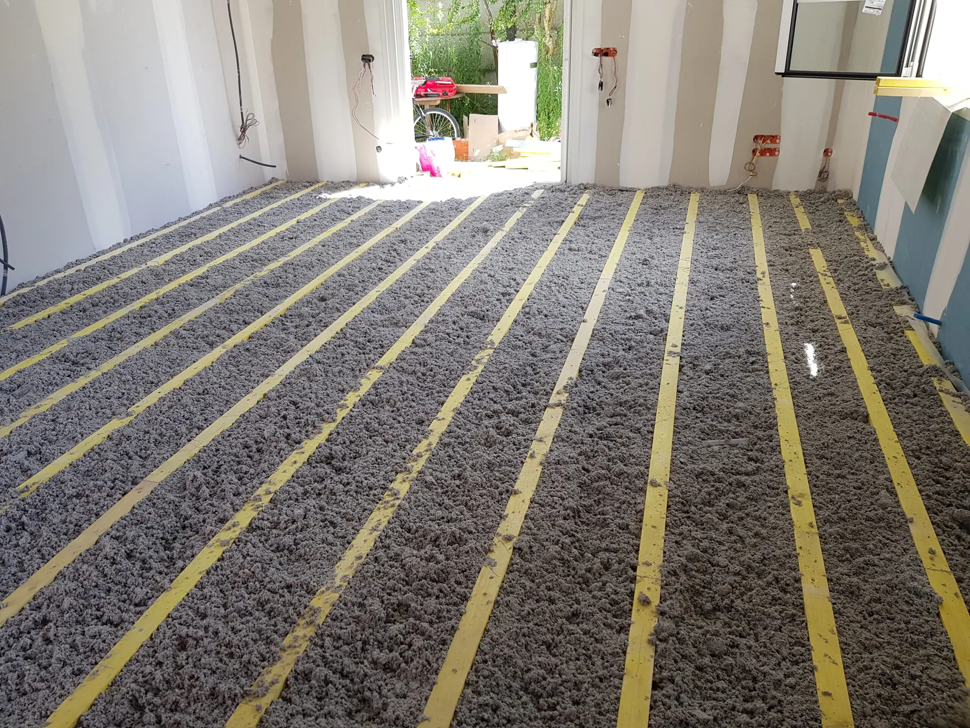 Préparation d’un support sur lambourdes avec isolant avant la pose du parquet.
