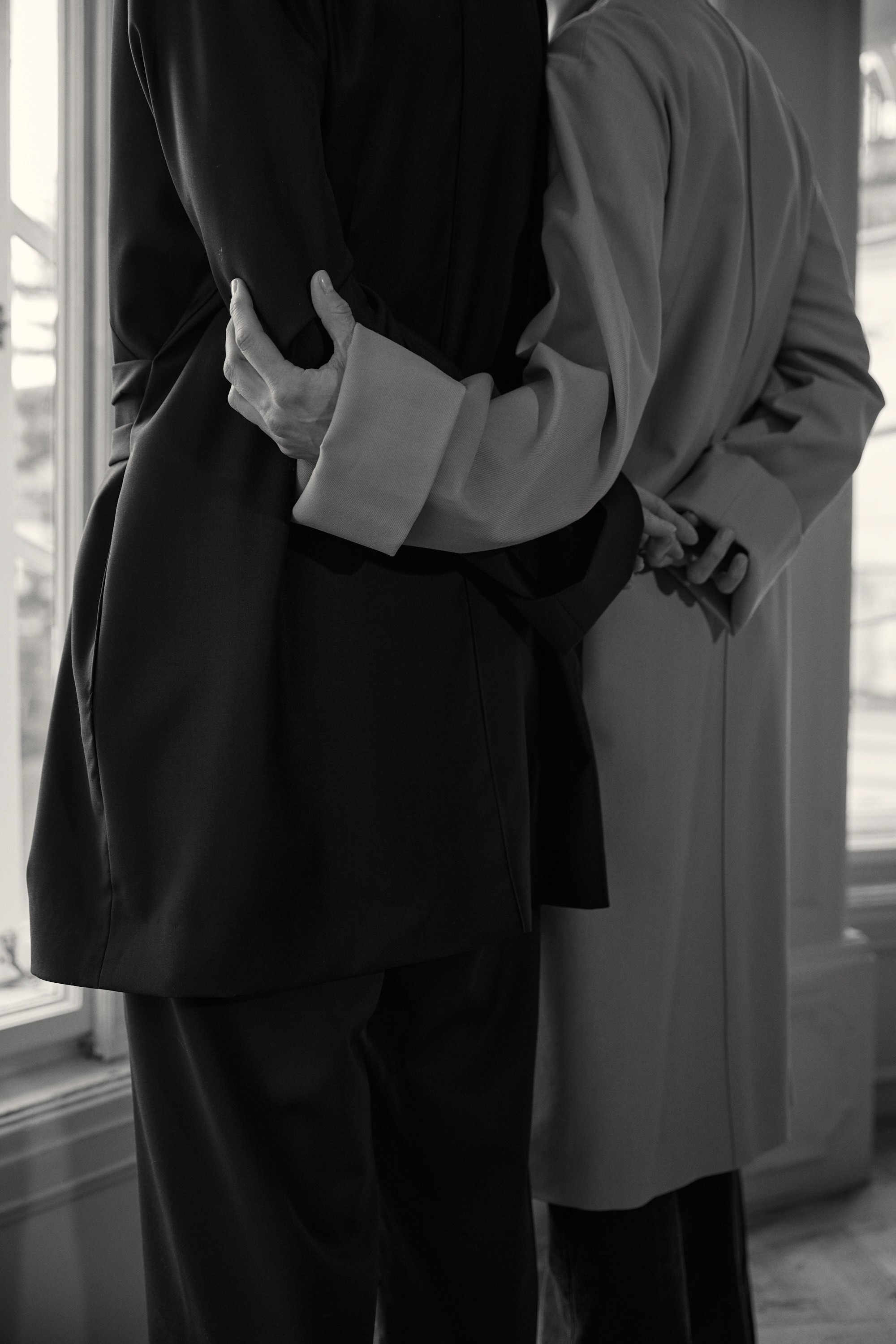 Organic gold metal ring sculptures resting on sketch paper with circular hand-drawn designs, lit by warm natural light.