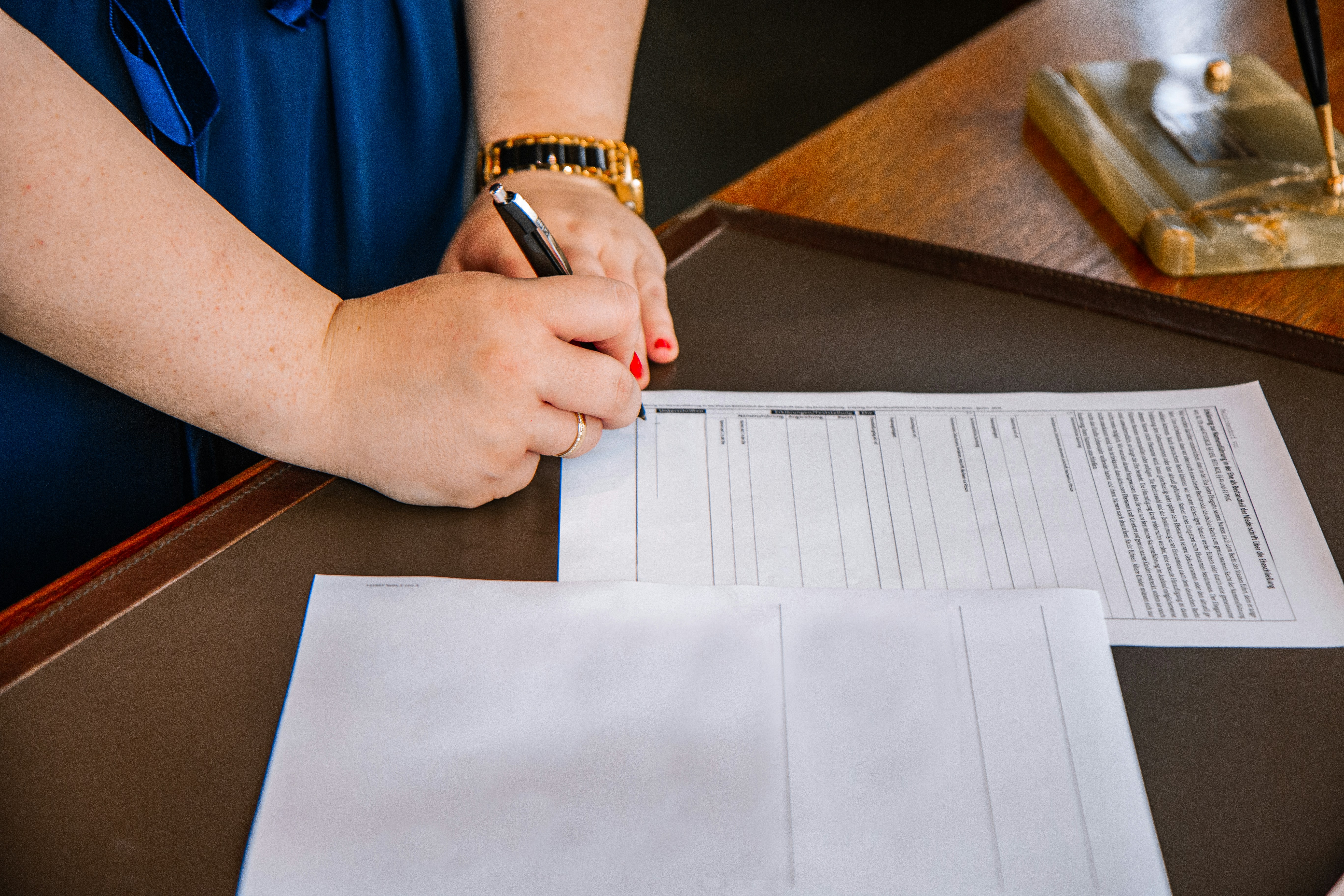 Someone signing two pages on a desk