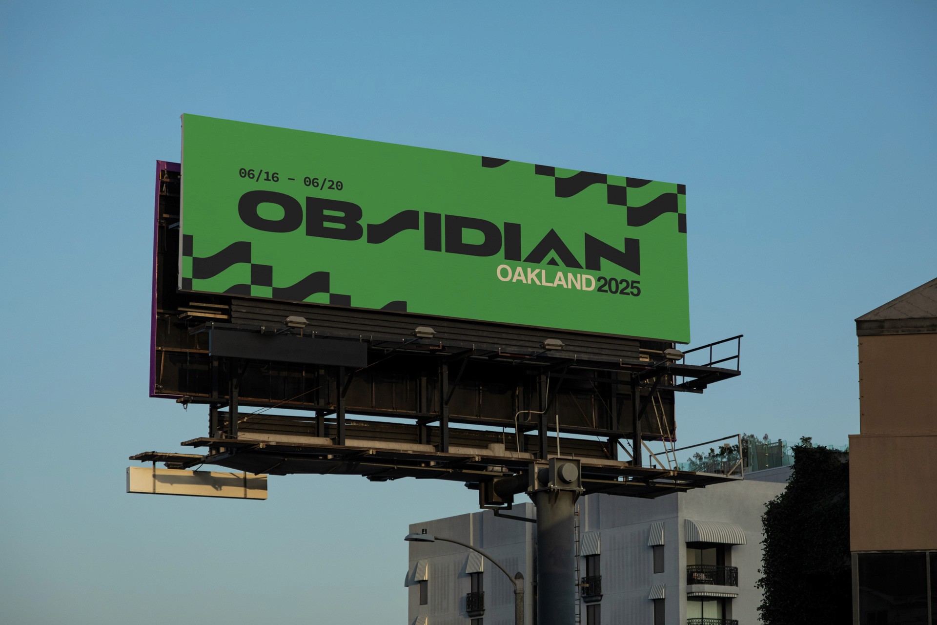 The image shows a large, rectangular billboard mounted on a metal structure against a clear, light blue sky. The billboard is predominantly green with a black geometric pattern. The text "OBSIDIAN" is displayed in black letters at the top left, with "OAKLAND 2025" written below it in white letters. The bottom right corner of the billboard shows “06/16 - 06/20”. The billboard is angled slightly downward. Below the billboard, a portion of a light-colored building with dark windows is visible, and a streetlight or light fixture is attached to the structure.