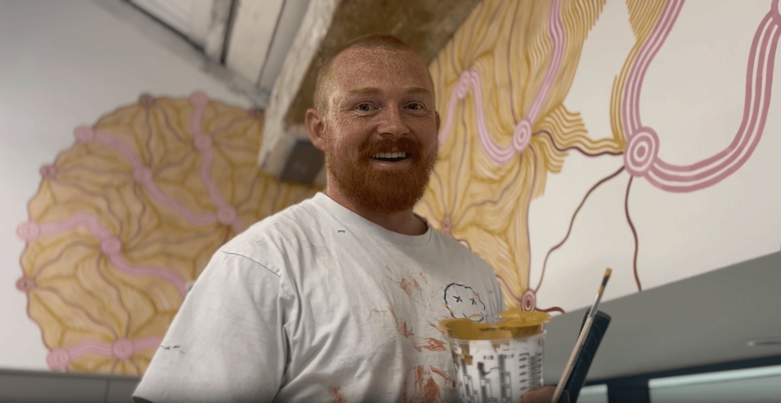 Photo of artist, Melnunnie, in front of mural