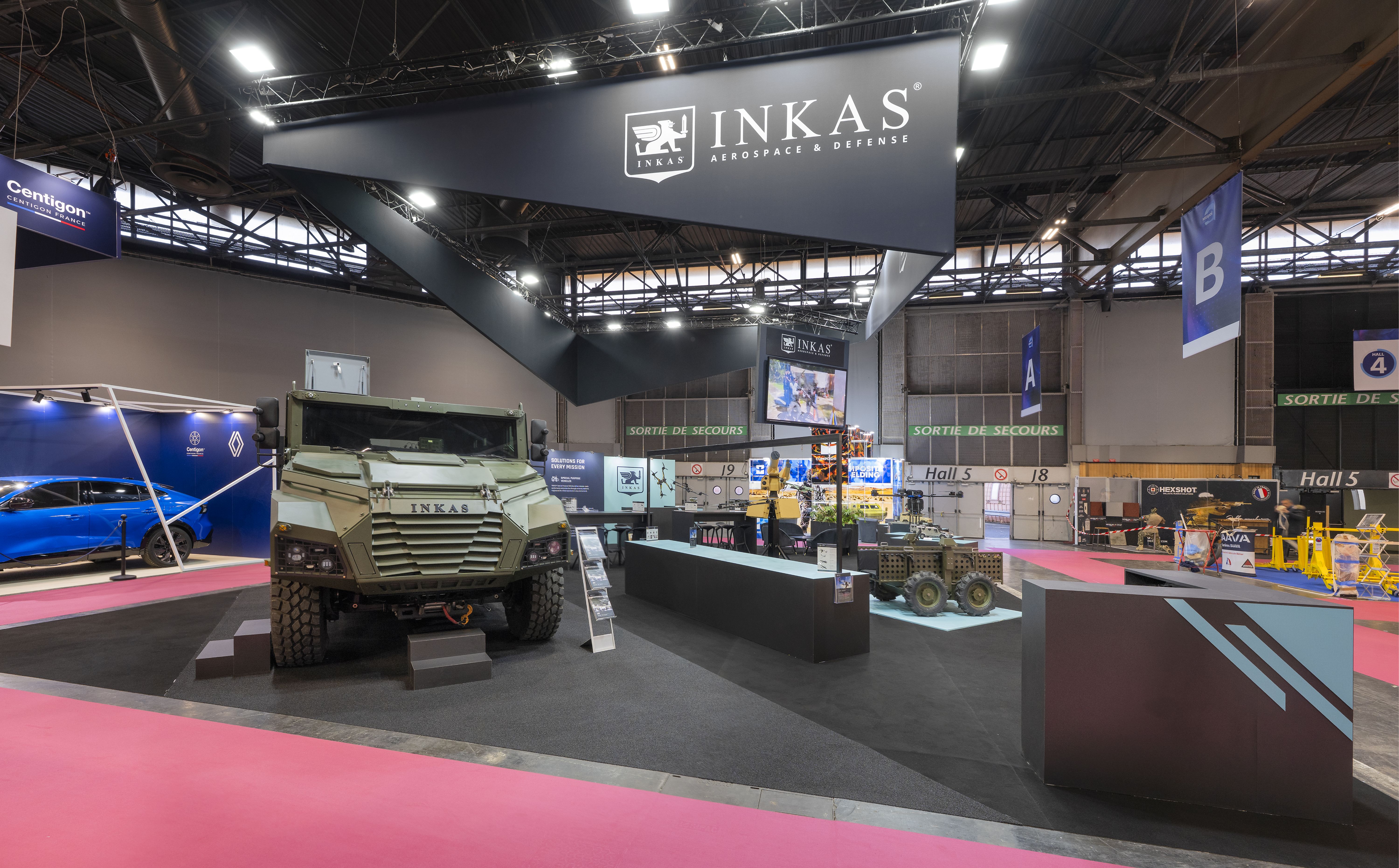 Stand INKAS Milipol Paris 2025 – vue d'ensemble du stand sur-mesure avec véhicules blindés, conçu par Expace