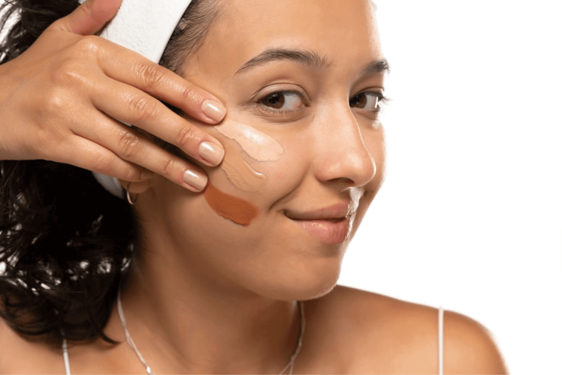 Close-up of a woman applying different shades of concealer on her face for a natural and radiant look.