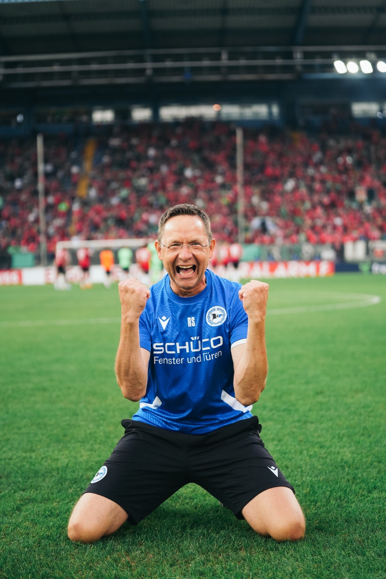 Jubelnder Spieler von Arminia Bielefeld kniet auf dem Rasen