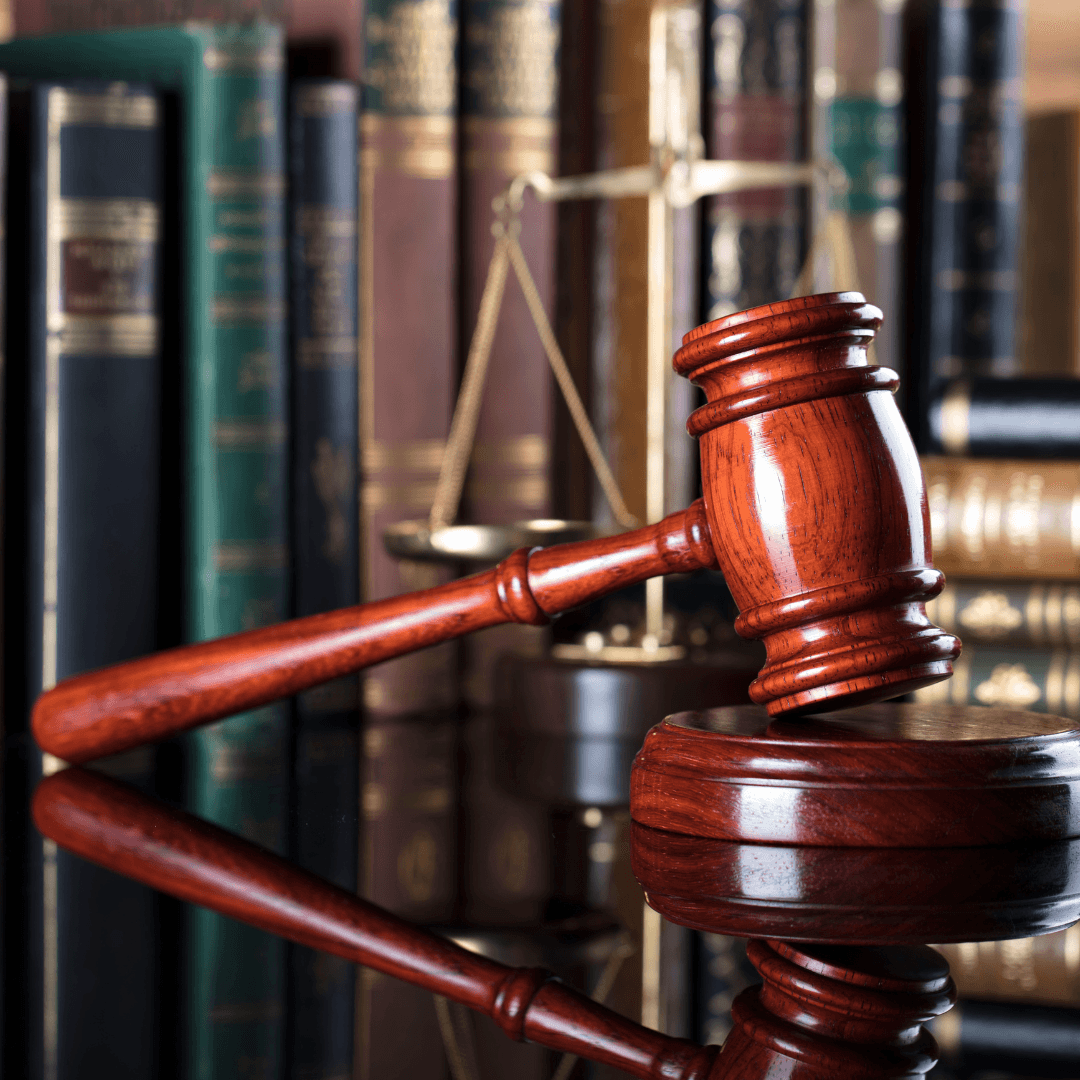 A lady standing, showing a chart on a board while people seated are looking at the board.
