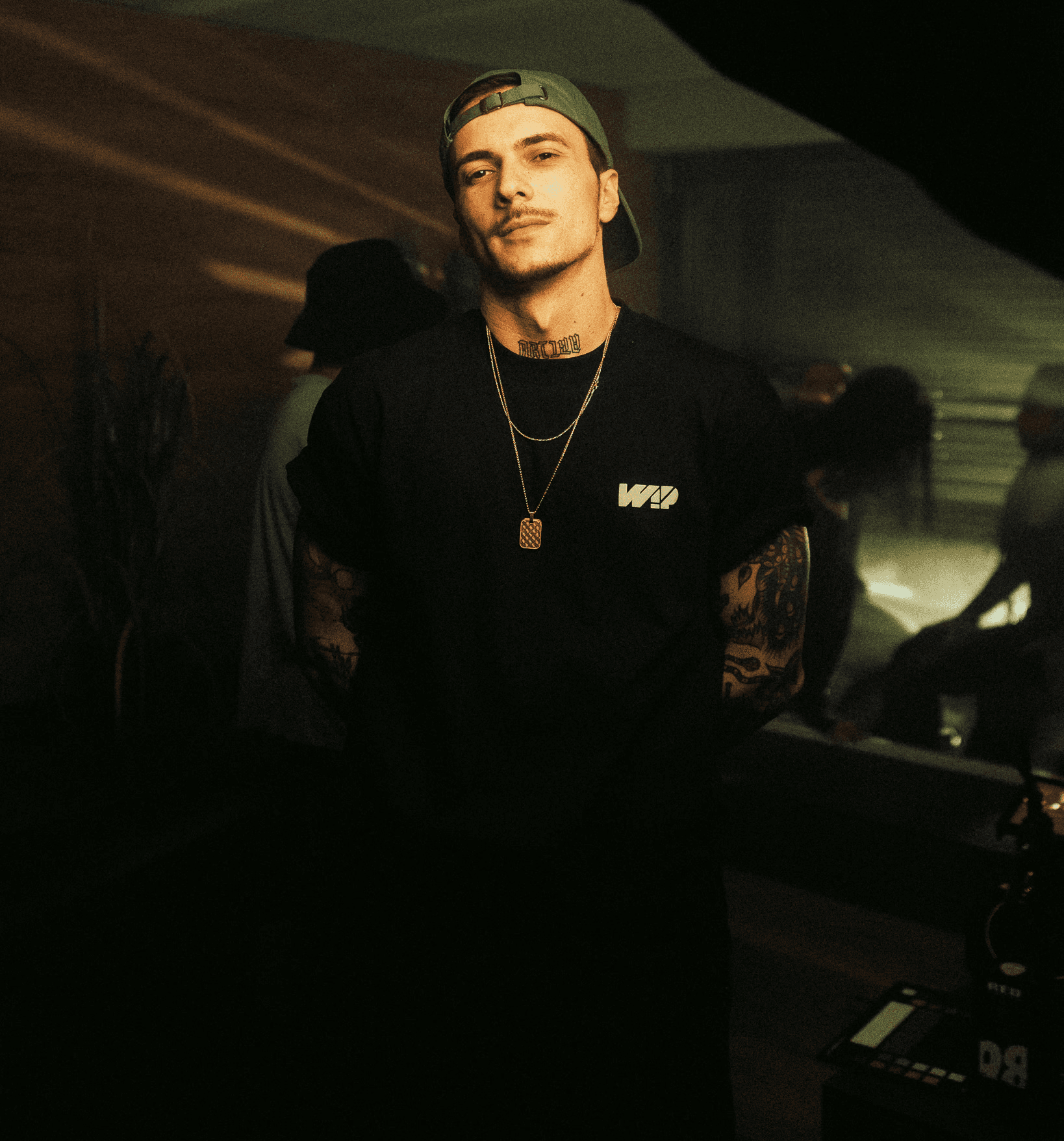 videoproducer with gold chain and green cap