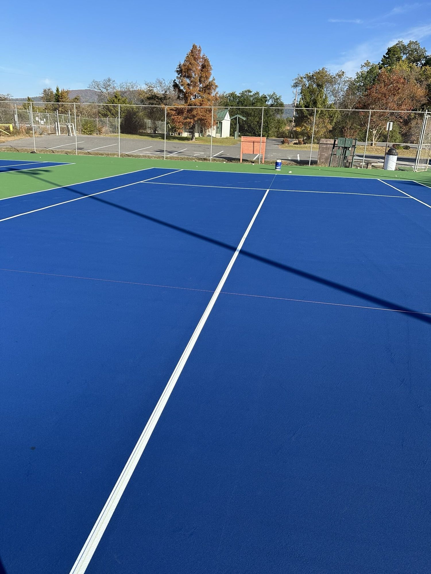 Resurfaced navy blue tennis court viewed from the baseline at Kimery Park in Hot Springs, AR