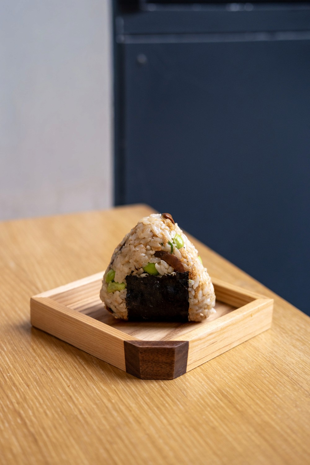 Freshly baked Margherita pizza with melted cheese, tomato sauce, and basil leaves, held by a person’s hand.
