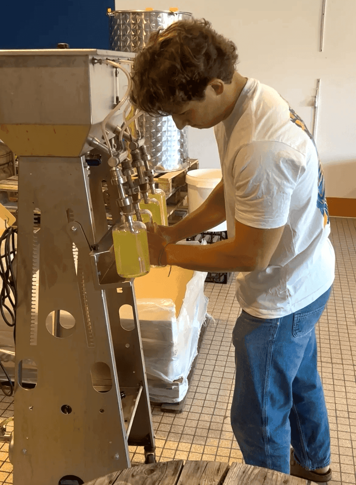 Mise en bouteille artisanale des liqueurs Madam Goûte avec machine de remplissage professionnelle