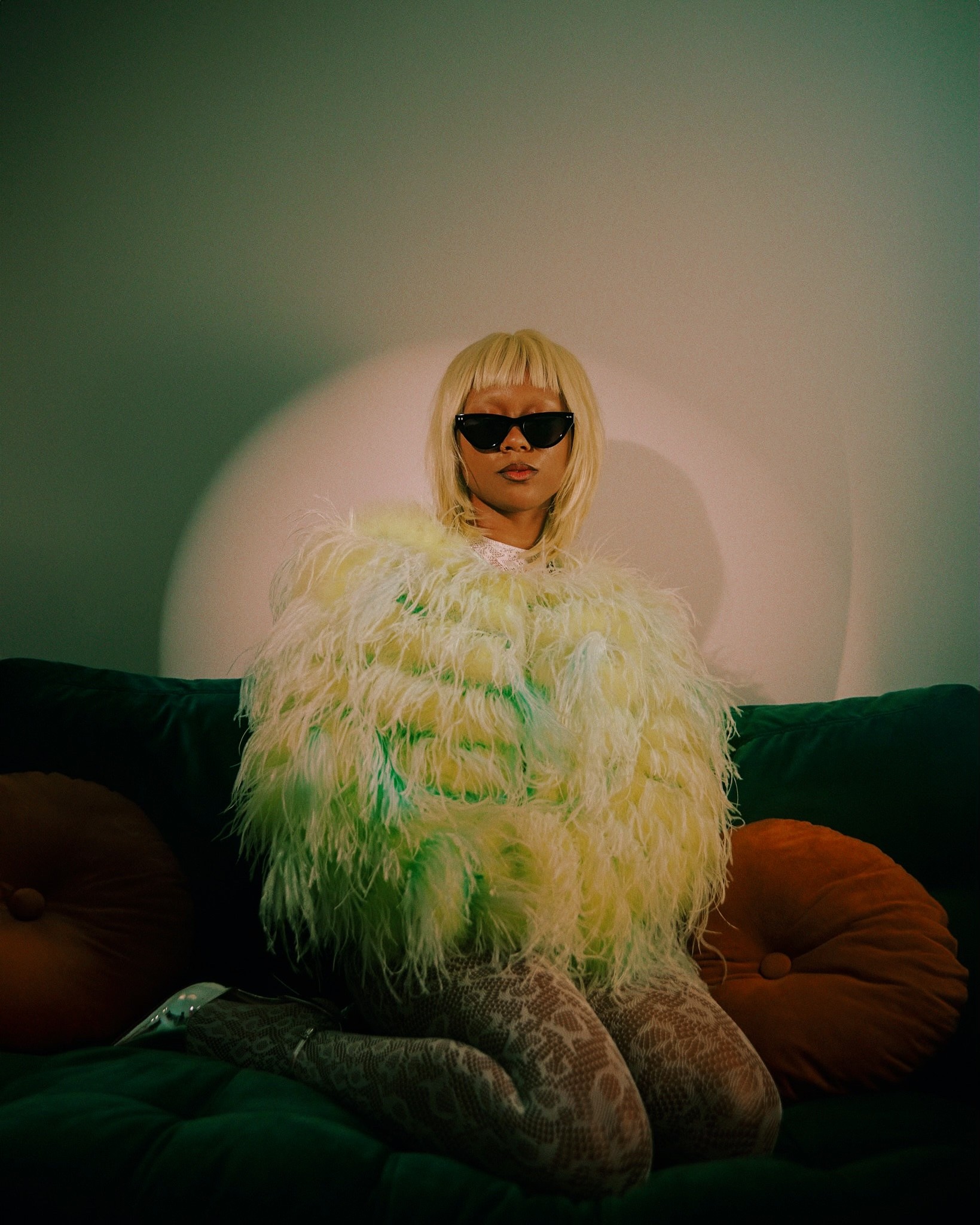 A tan sighthound stands in a grassy field.