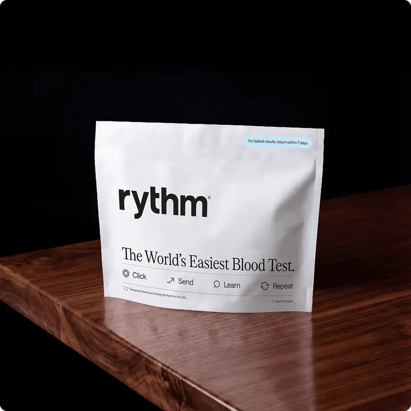 Rythm at-home blood test kit package placed on a wooden surface, showing branding and product details.