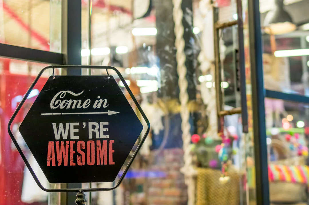 sign in window of store saying "Come in we're awesome"