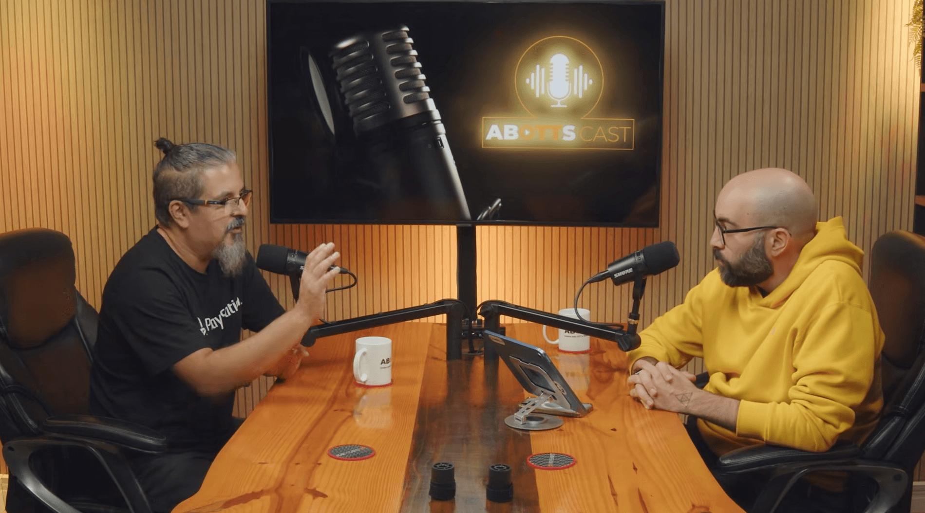 Imagem aberta de um mesacast, com dois homens com uma mesa ao meio