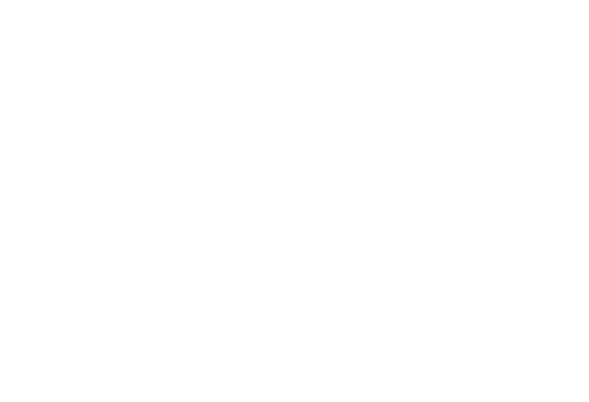 men and women sitting and standing by the table looking happy while staring at laptop