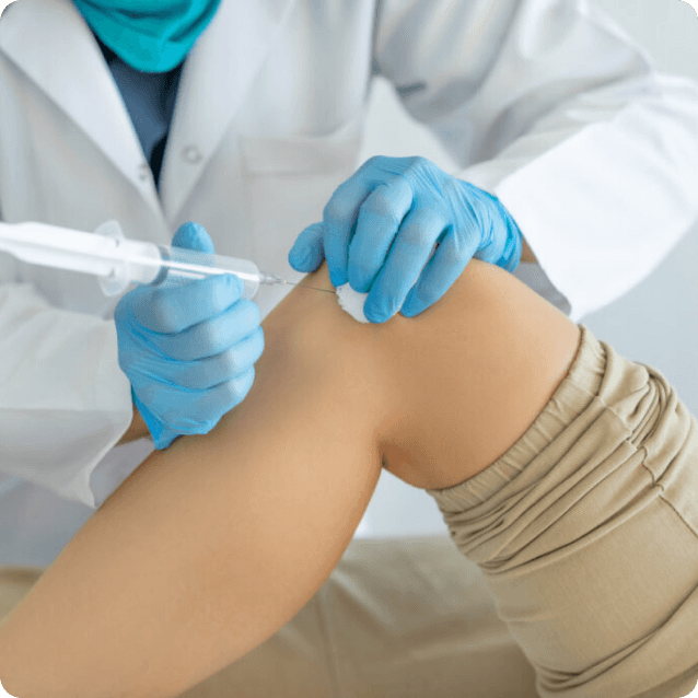 Close-up view of a medical professional injecting mother cells (stem cells) into a patient's knee joint, showcasing the syringe and injection site. The patient has a neutral expression, and the clinical setting emphasizes the procedure aimed at promoting healing and regeneration in the knee area.