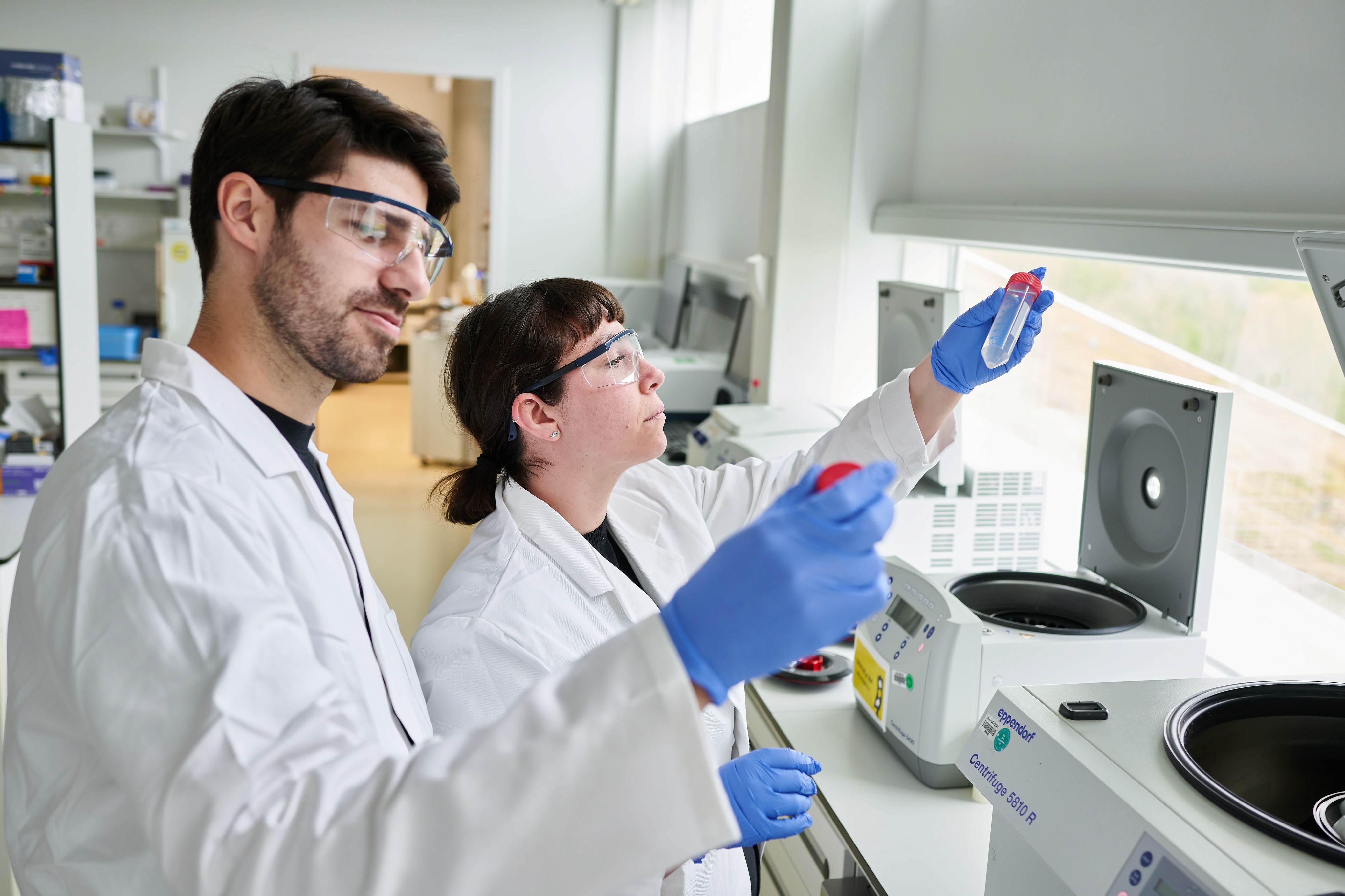 3 people in a lab with one writing on a whiteboard