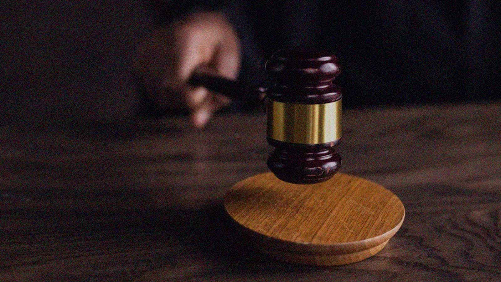 Foto de una mano que golpea un martillo de juez sobre una mesa en la columna de opinión Procultura: Justos por pecadores de IdeaPaís.