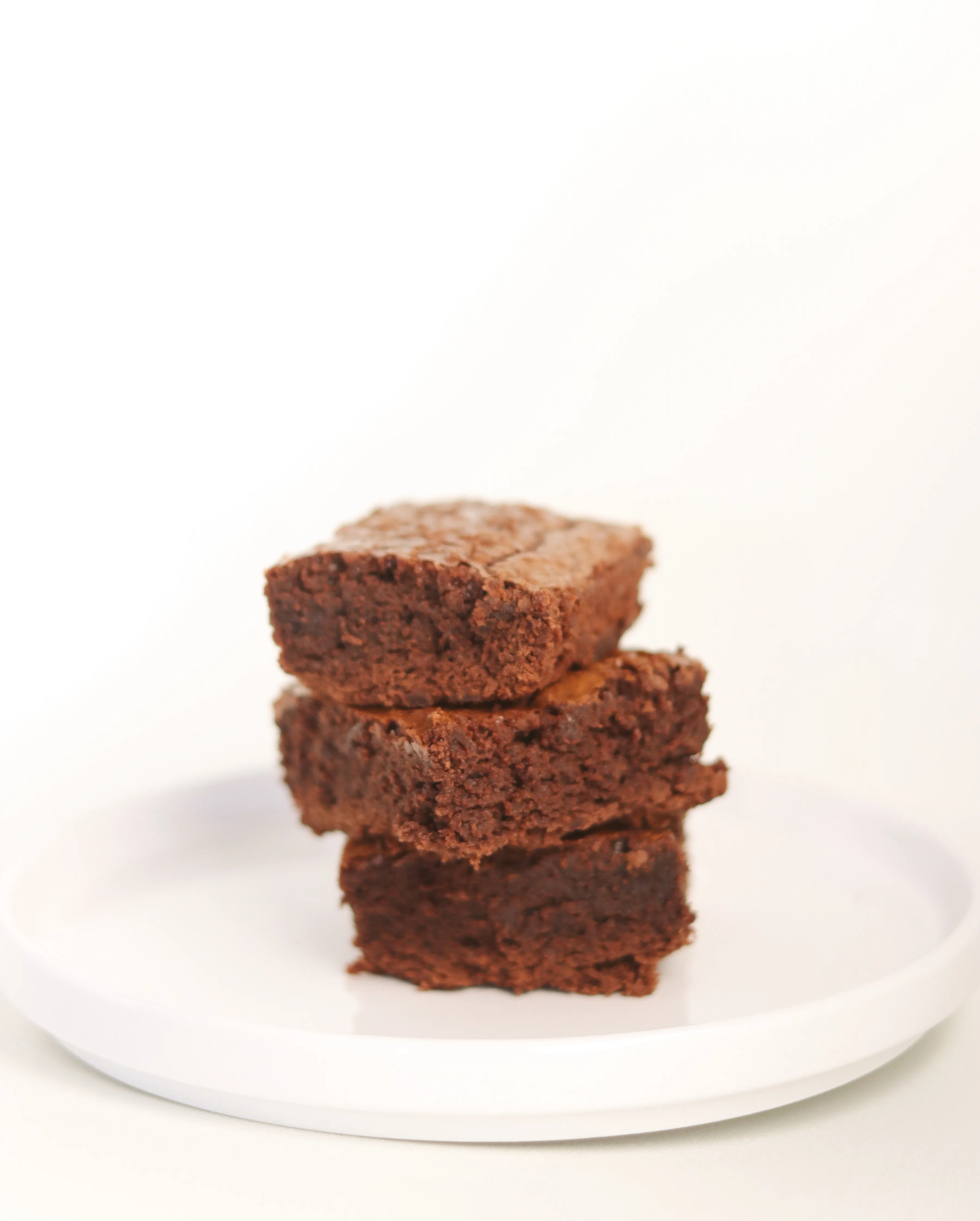 Torre de brownies caseros apilados sobre plato blanco