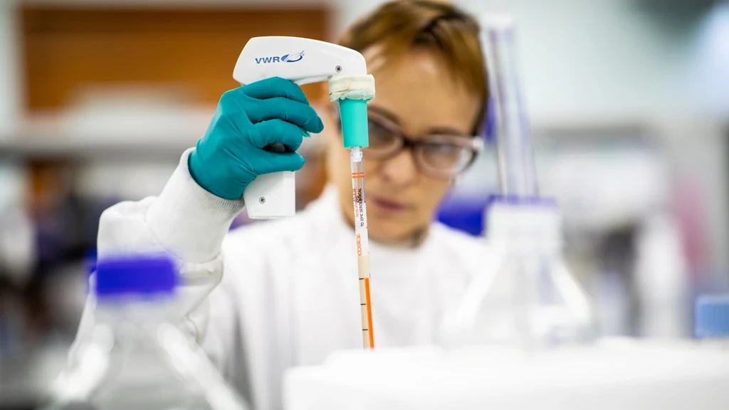 CPI scientist using a VWR pipette controller to fill a serological pipette in a laboratory.