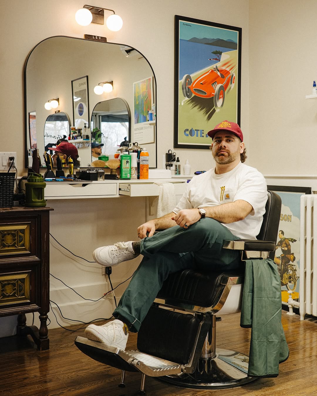 Lev wearing a white t shirt sitting in the barber chair