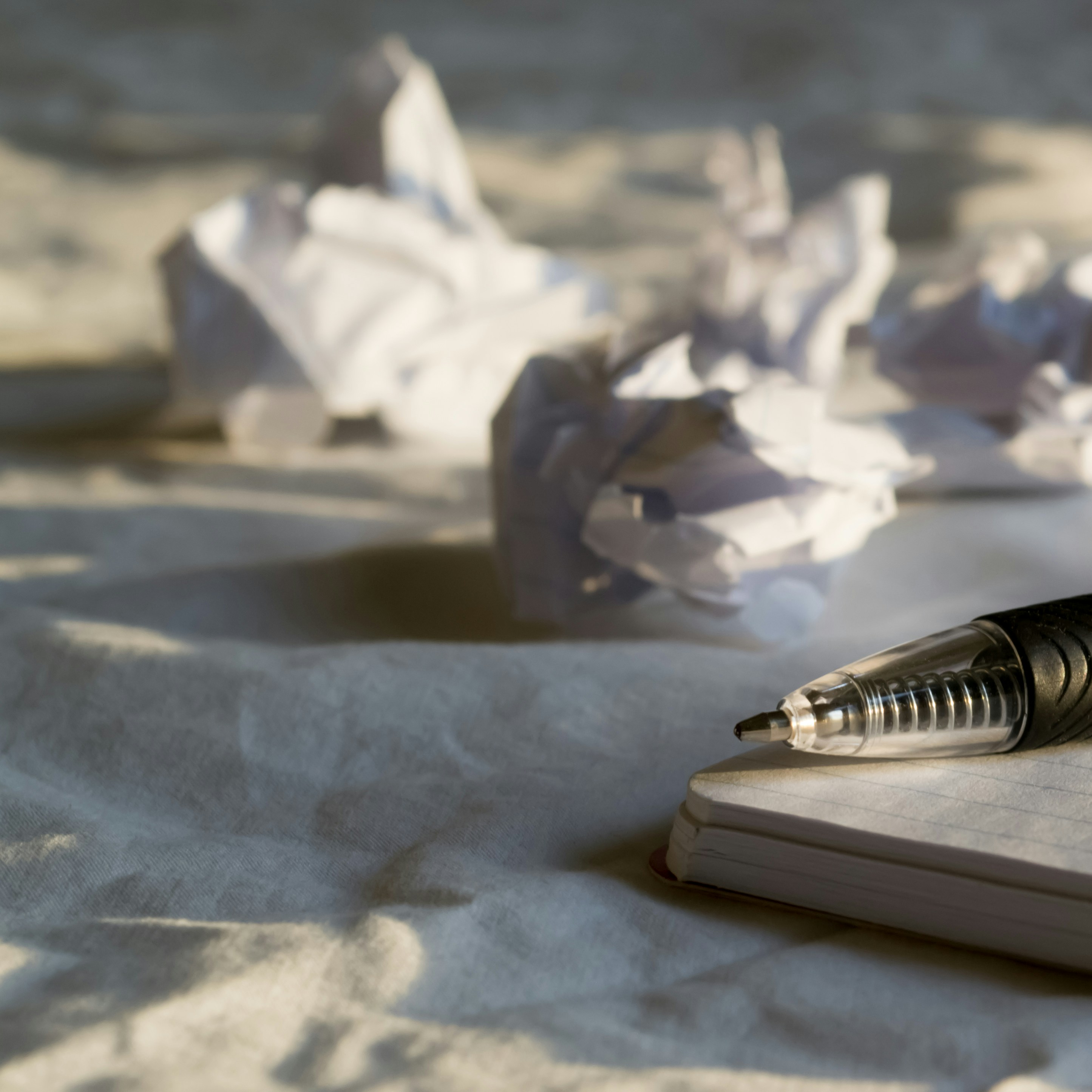 Pen resting on a notebook beside crumpled injury report drafts