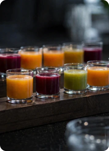 Seleção de sucos naturais coloridos servidos em copos baixos para coffee break e eventos corporativos sofisticados.
