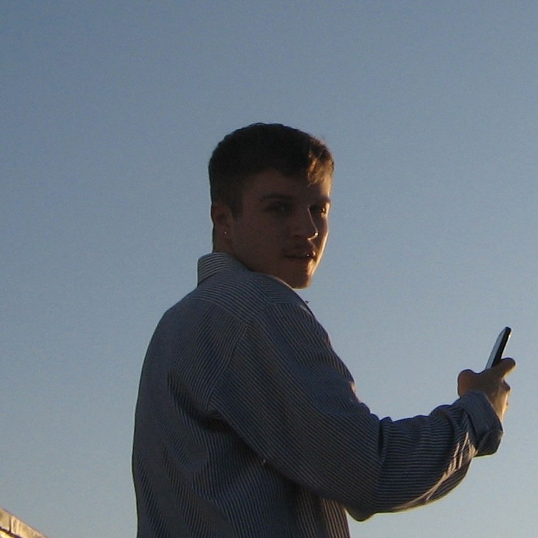 A thoughtful young person with dark hair gazes to the side, captured in soft black and white lighting.