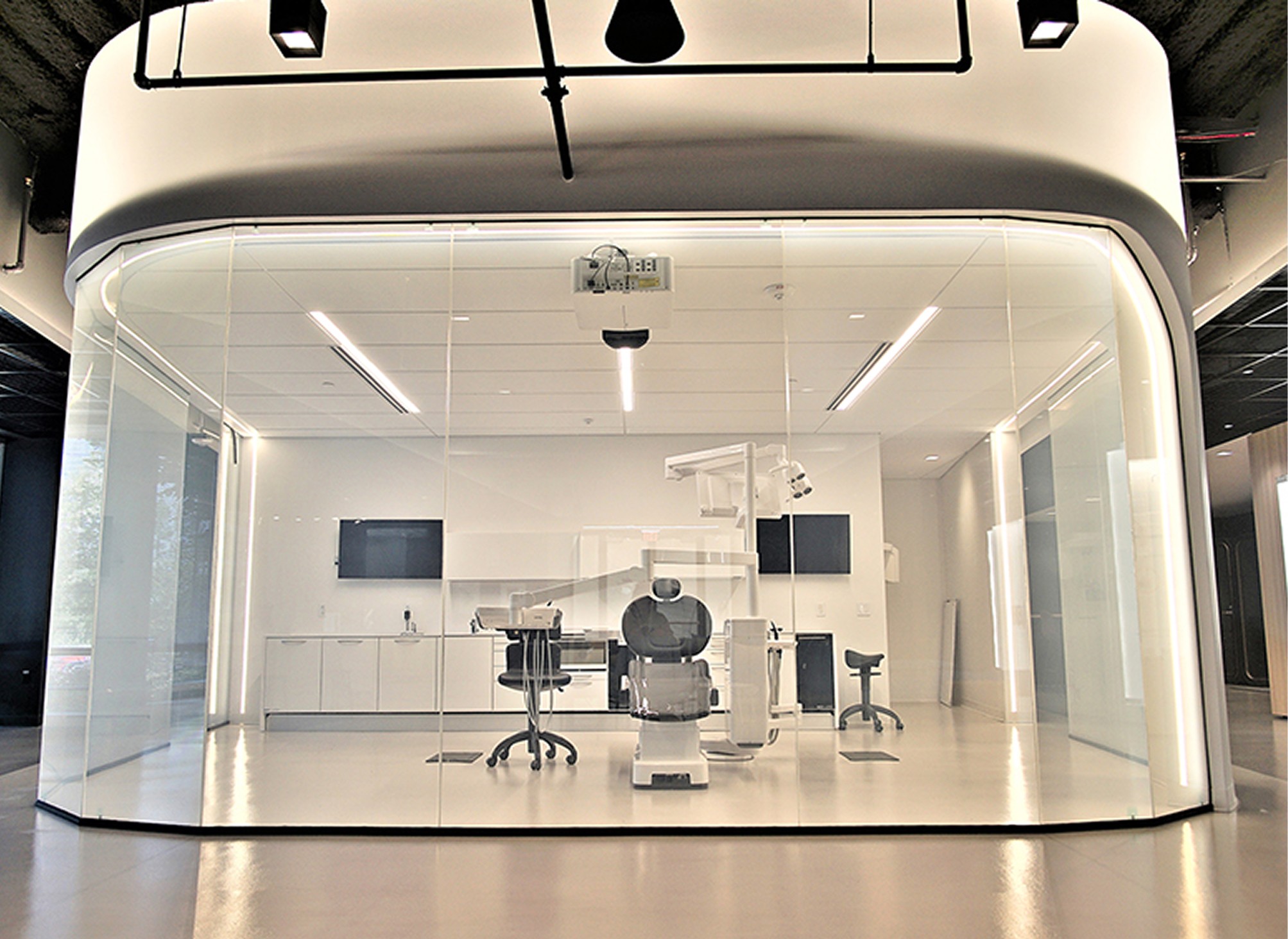 sala de reuniões em vidro com película inteligente em modo transparente revelando uma clínica dentária limpa