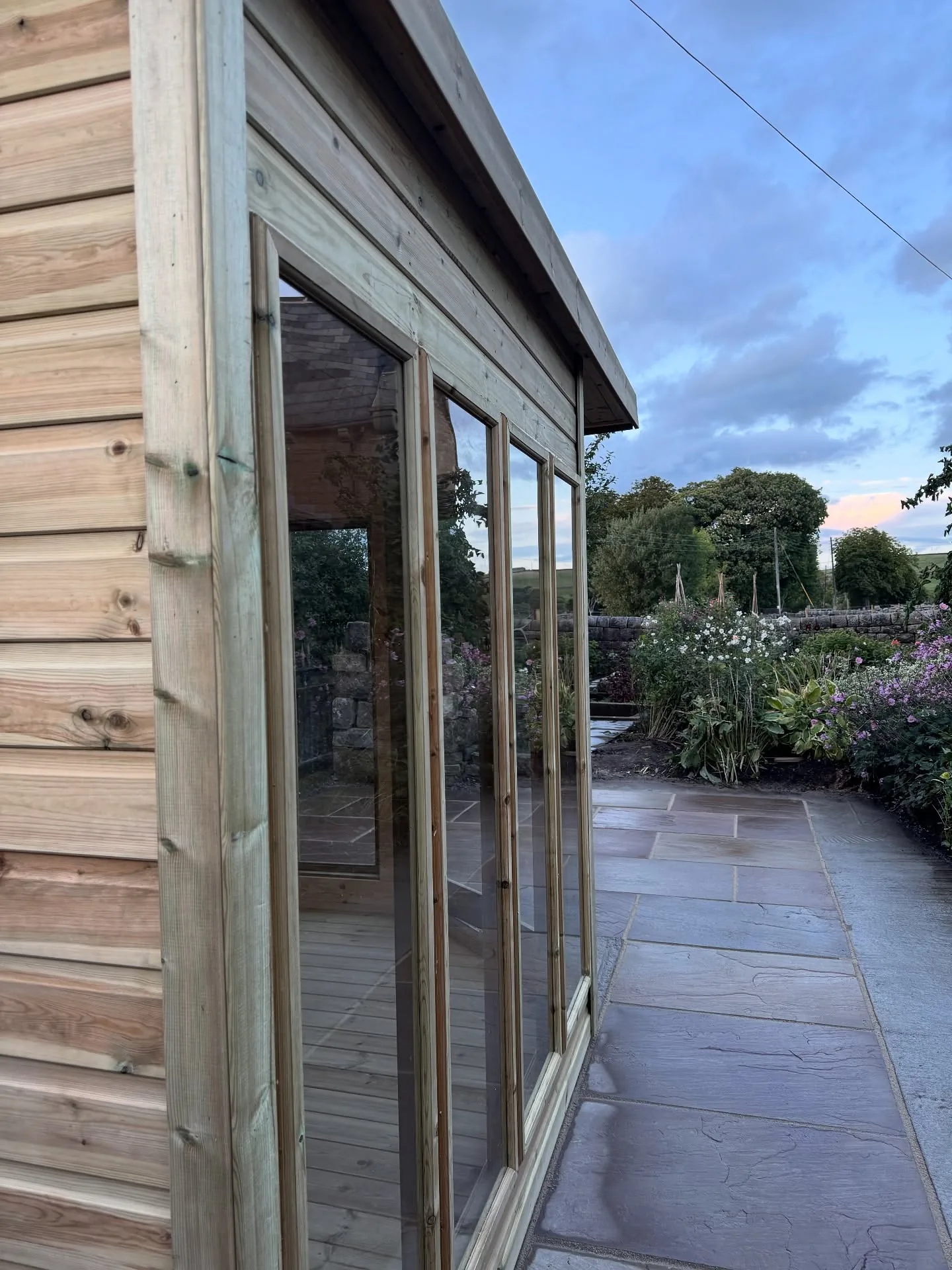 Timber summer house beside finished Indian stone paving in Todmorden