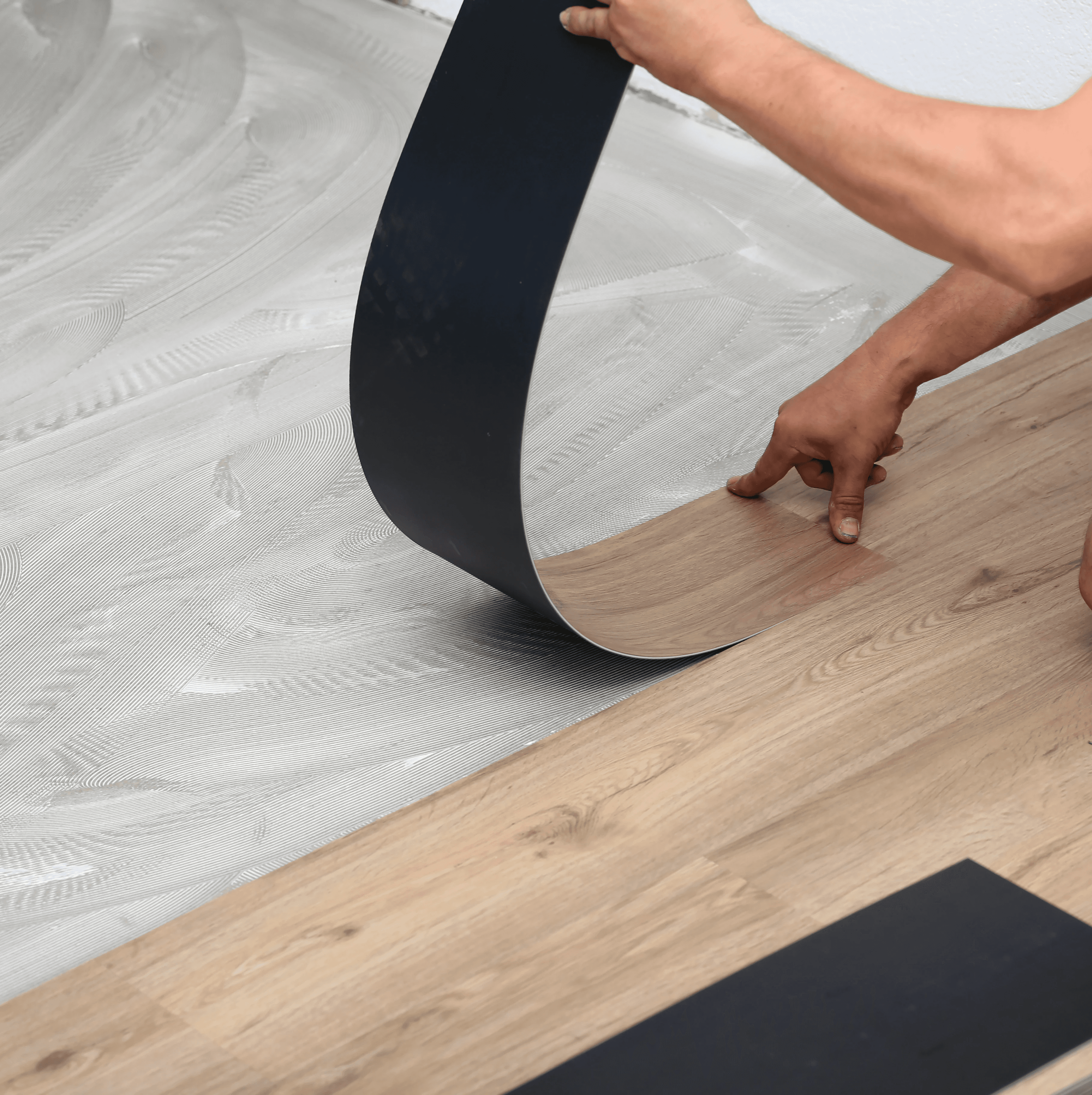 Installer flexing a luxury vinyl plank during a floor installation