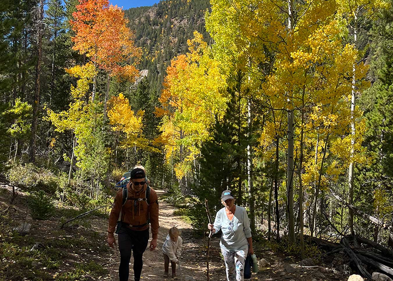 Mother, son and grandaugther hiking outdoors on a Fall day