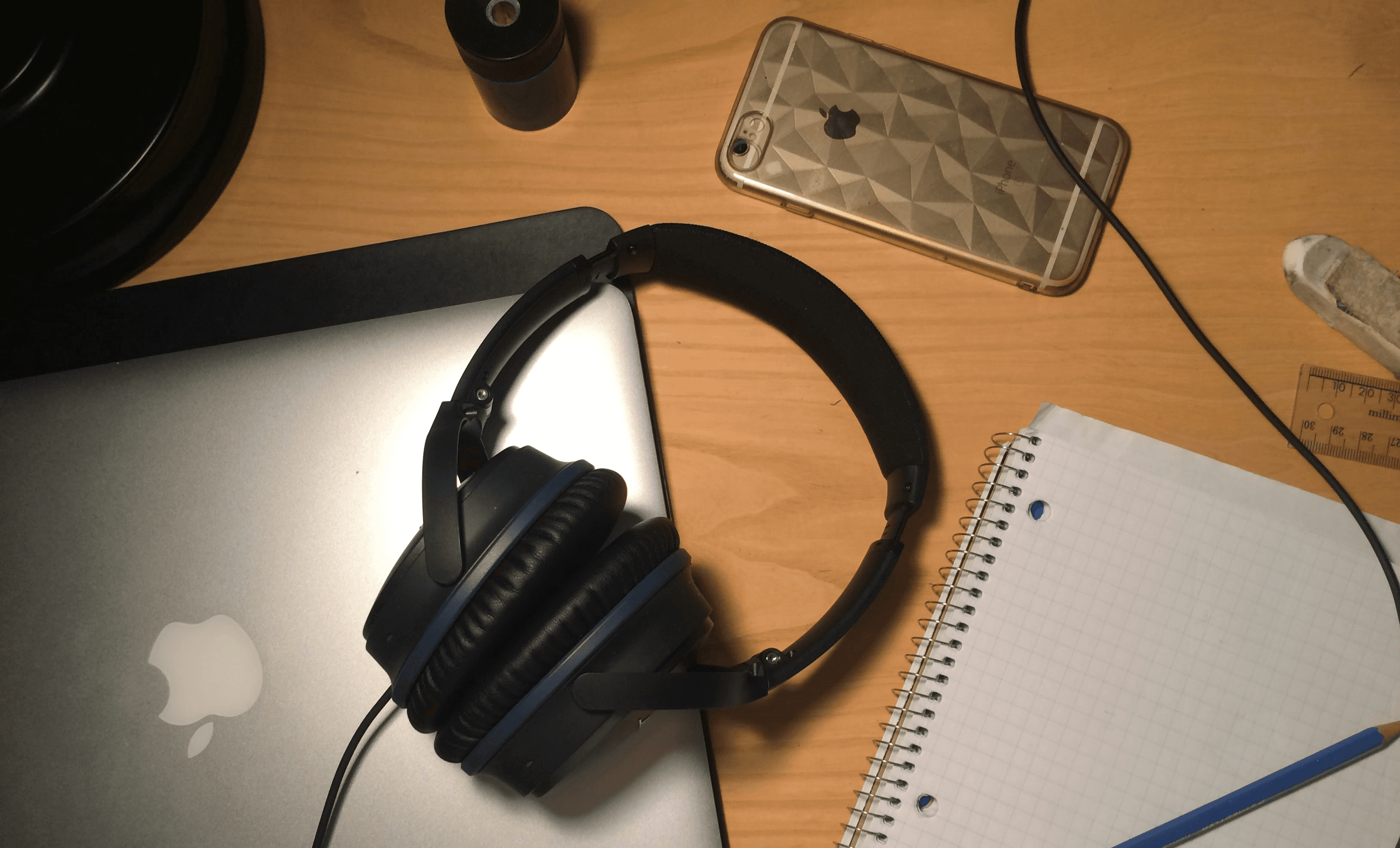 Headphones, laptop, and notes on a table. Photo by Francis Bouffard on Unsplash