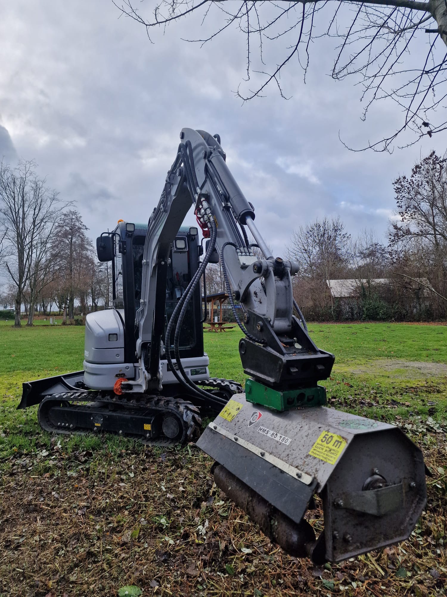 A row of trees that are in the grass