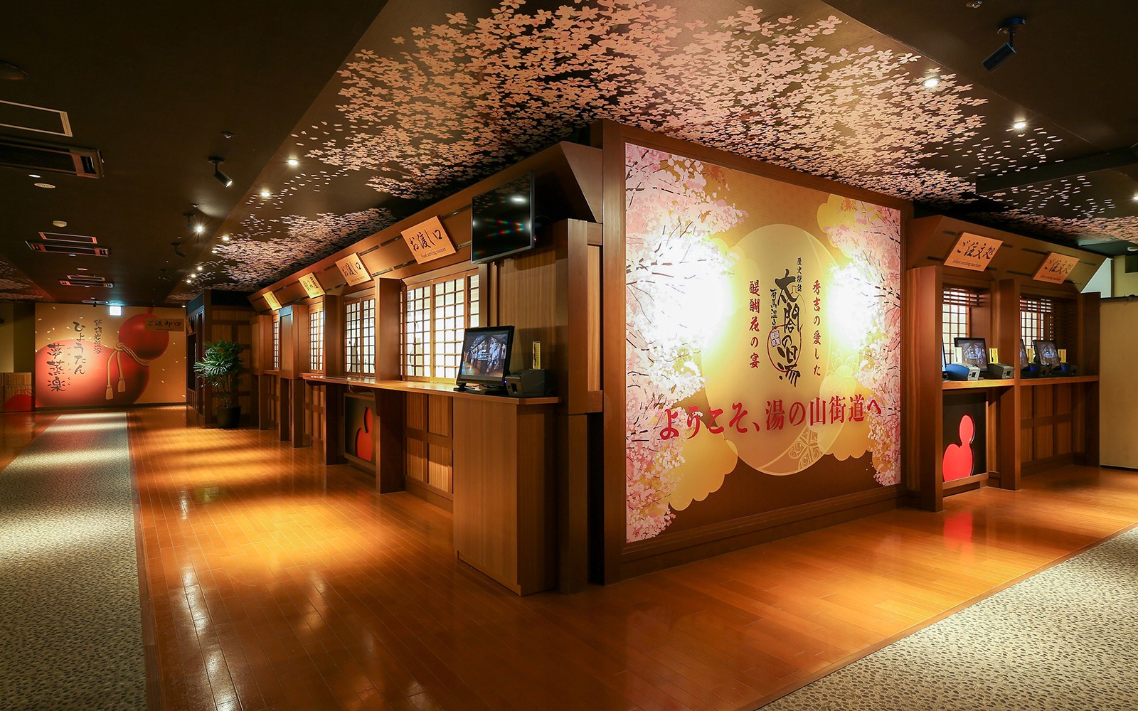 Arima Onsen Taiko No Yu Spa entrance with cherry blossom decor and ticket counters.