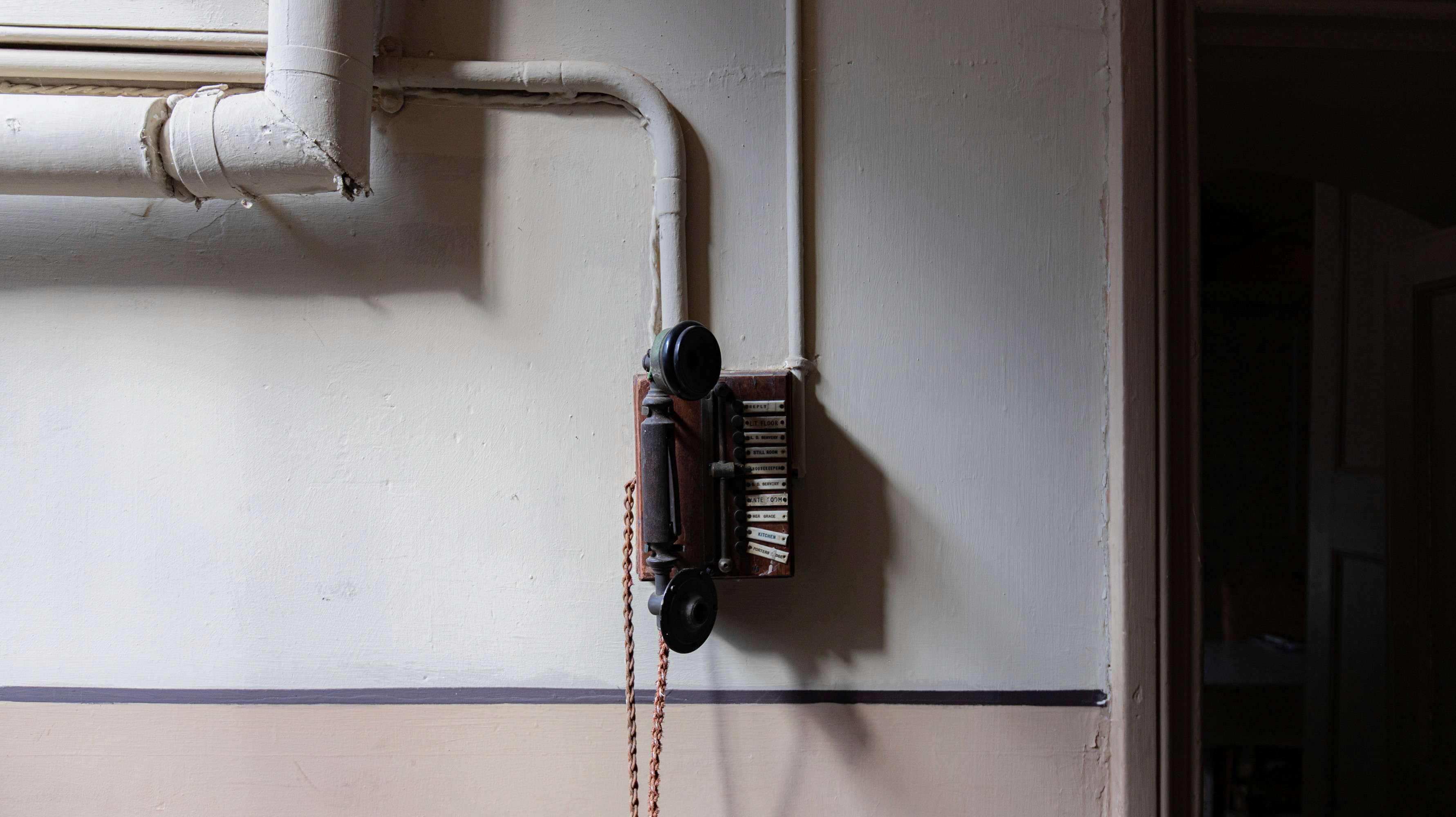 Two classic volkswagen beetles, one green, one cream.