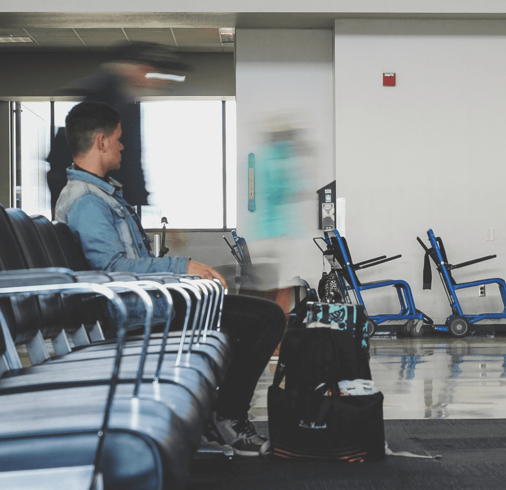 man sitting on chair watching female holding phone