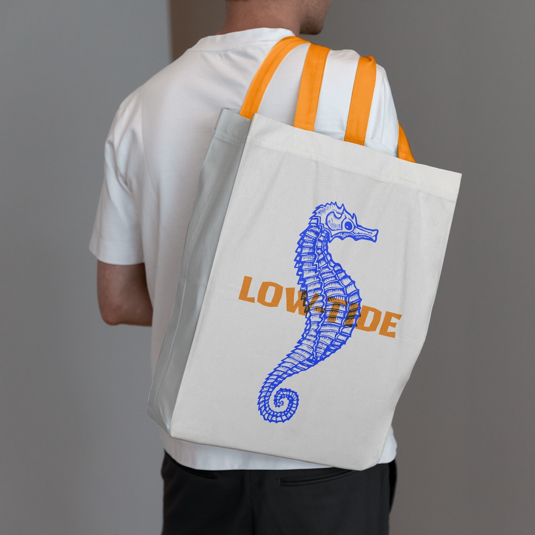 Low-Tide tote bag with a blue seahorse illustration and orange lettering.
