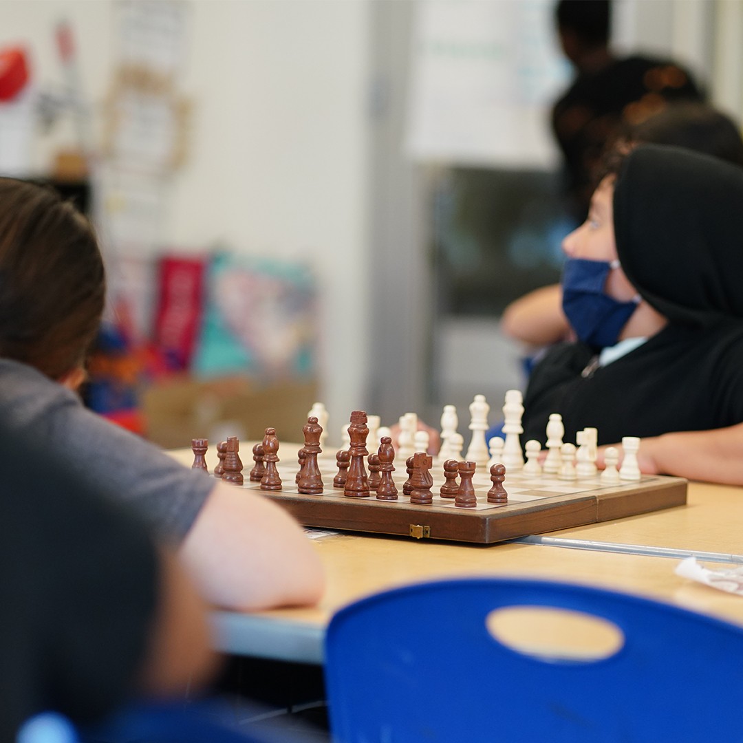 Students analyzing chess positions and planning moves in strategy-based class