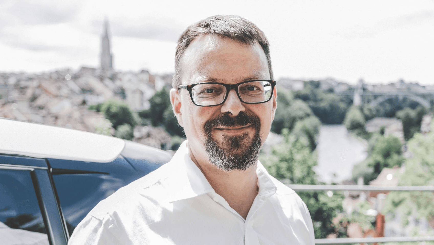 Portrait of the director of Swiss eMobility, Krispin Romang, with a scenic view in the background, representing leadership in advancing electric mobility and sustainable transportation in Switzerland