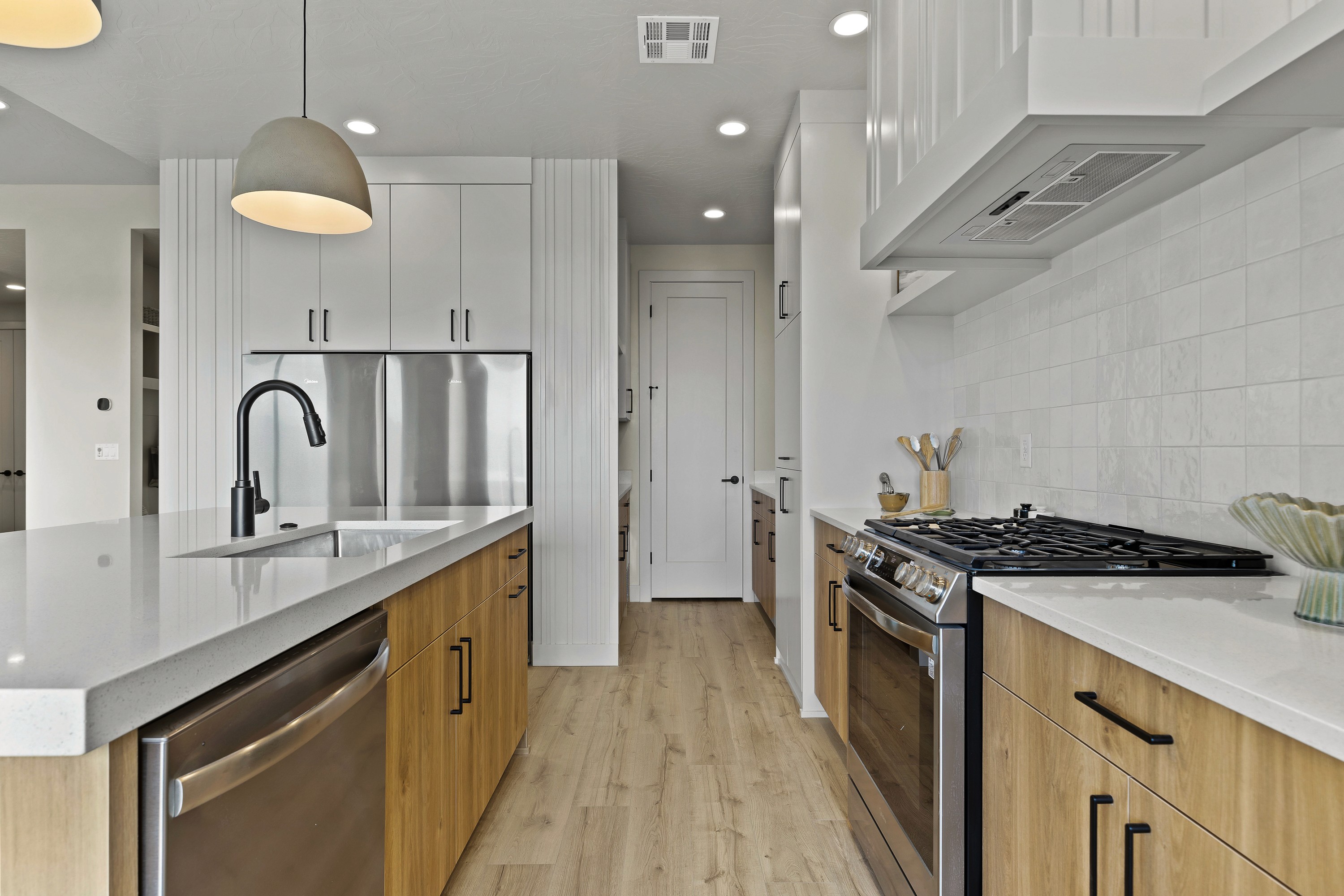 Detailed kitchen shot in the BYSO House in Hurricane, Utah highlighting cabinetry, countertops, and appliances.