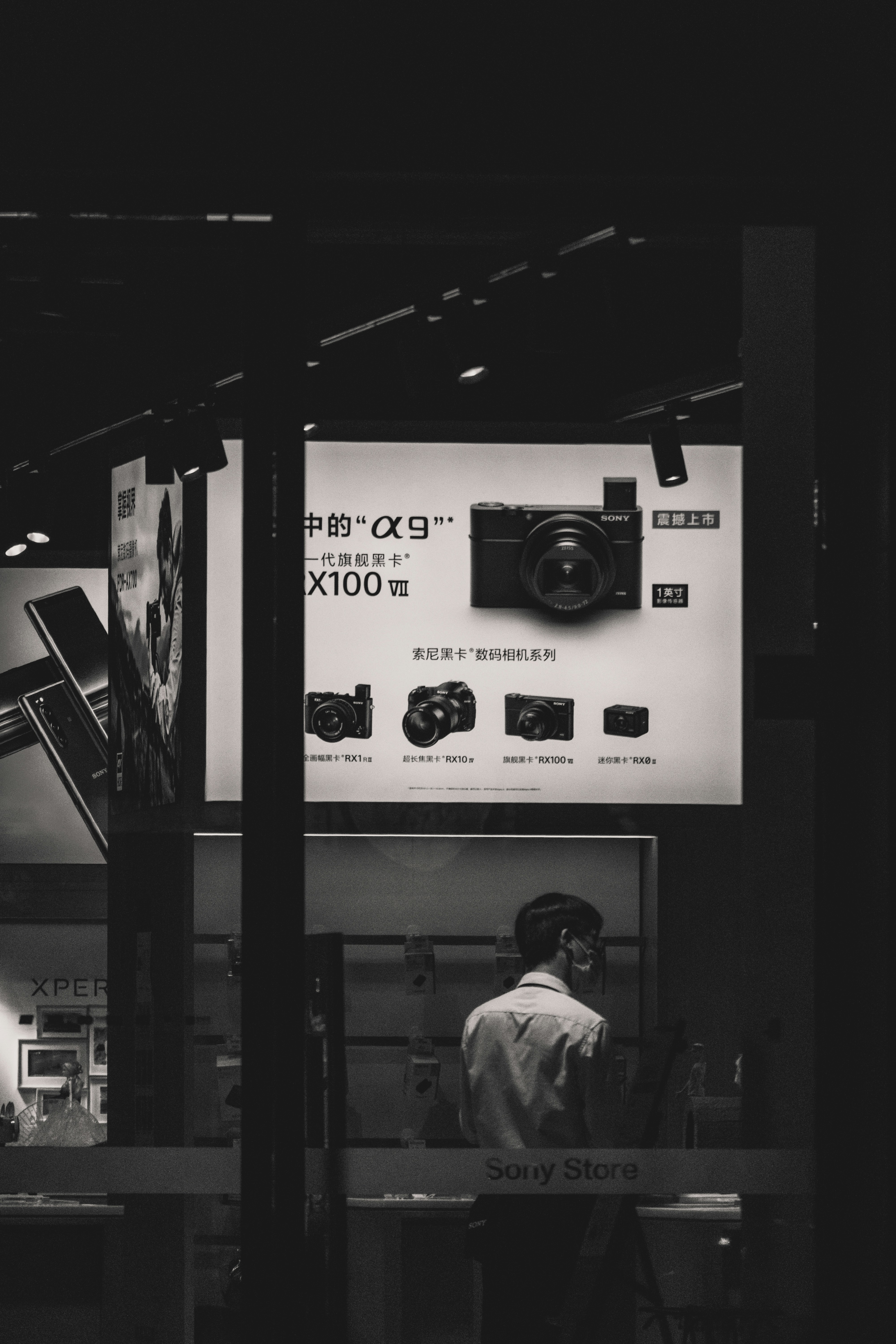 a black and white photo of a man looking at a camera
