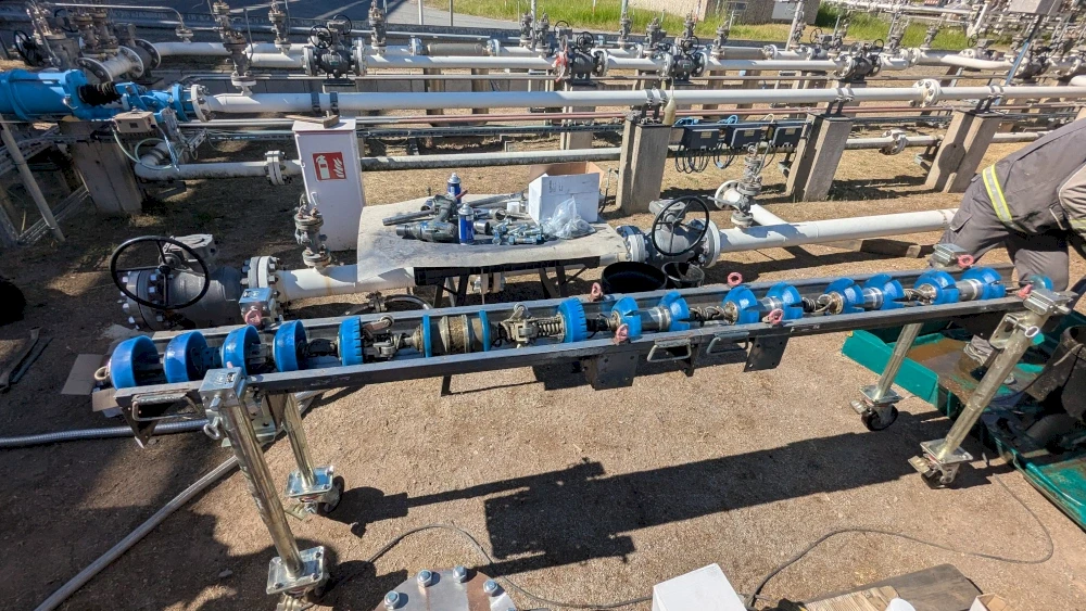 Man working on industrial pipes with valves and controls, part of gas or oil infrastructure.