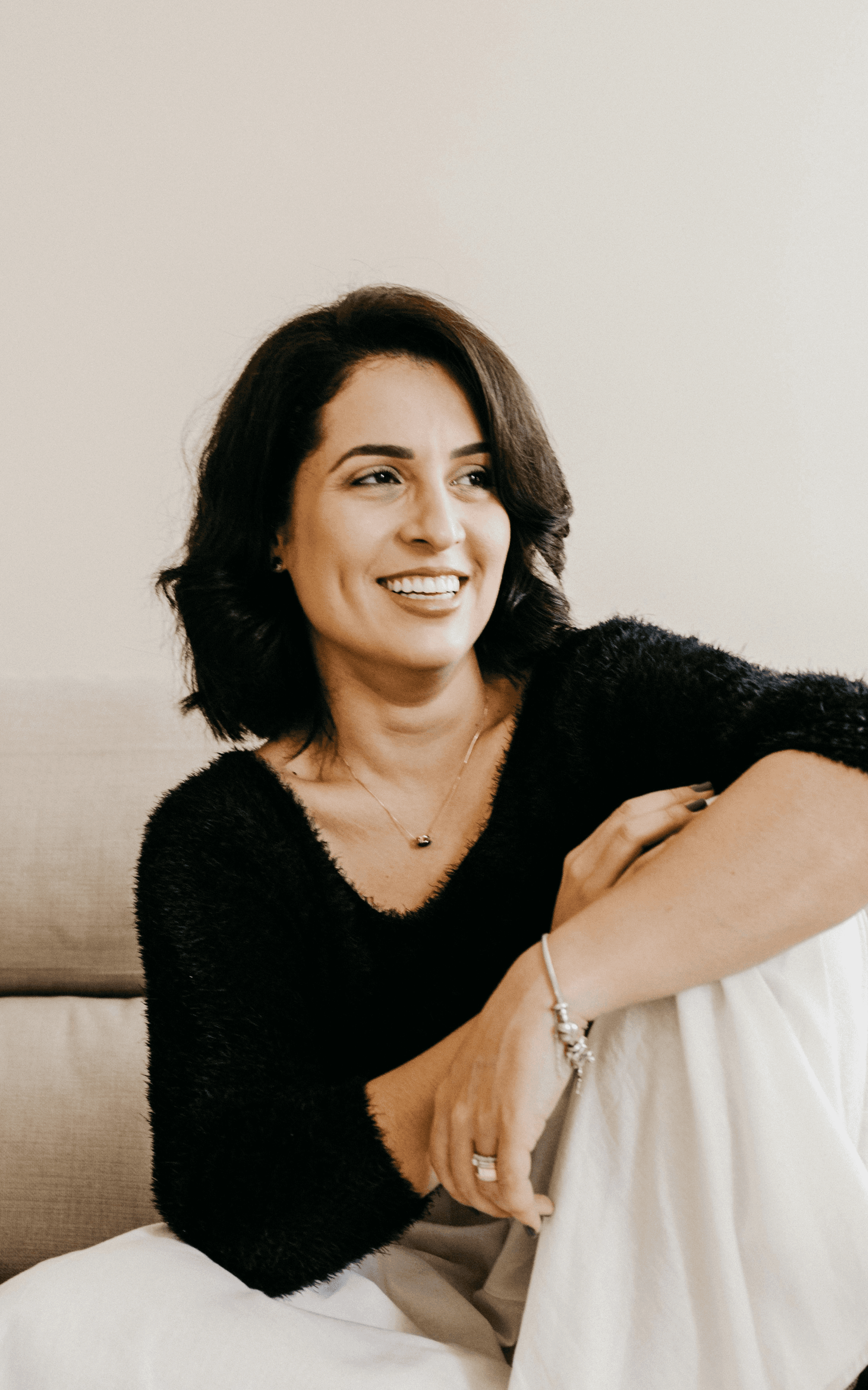 woman in black long sleeve shirt sitting on white couch