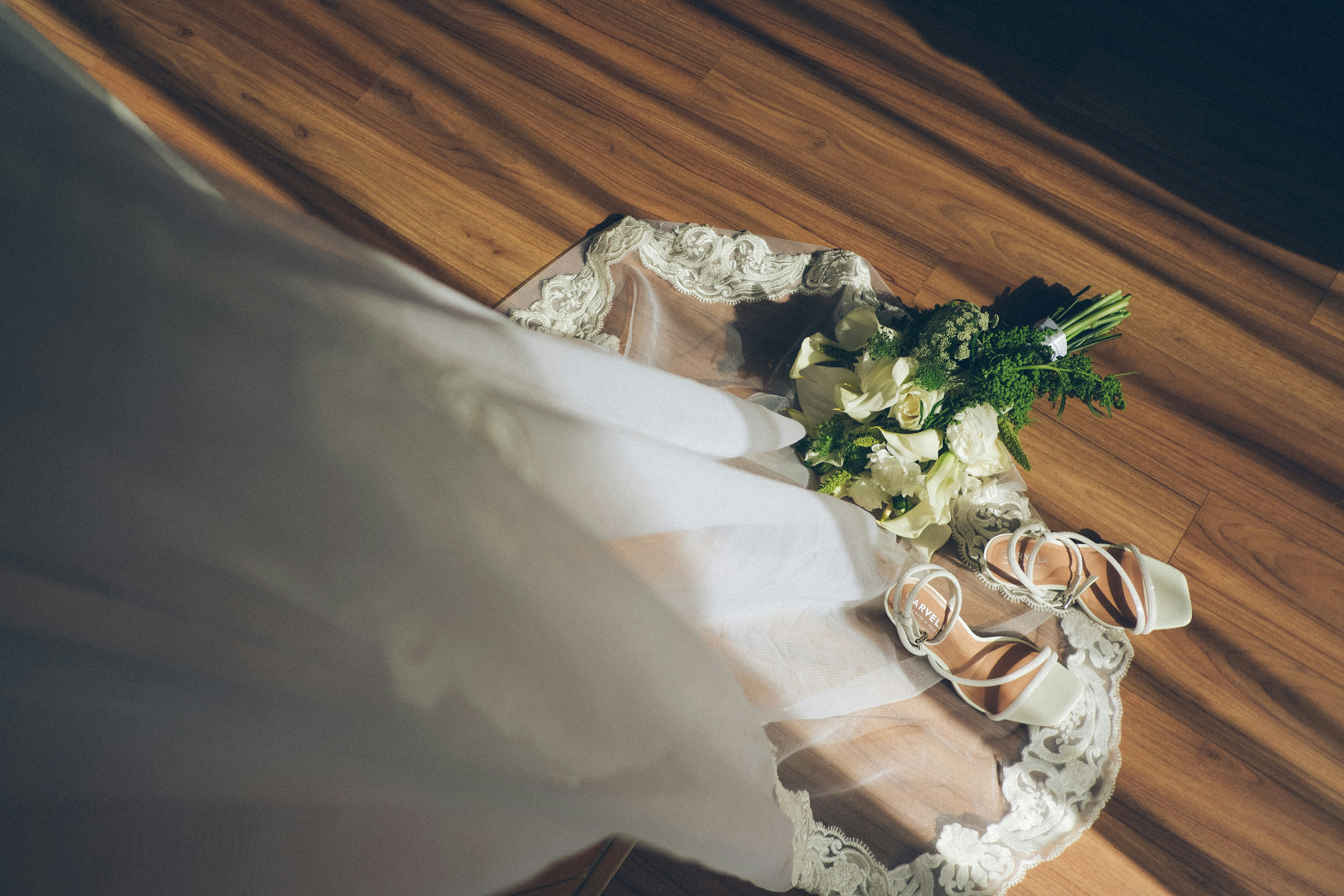 Wedding veil and bouquet on wooden floor