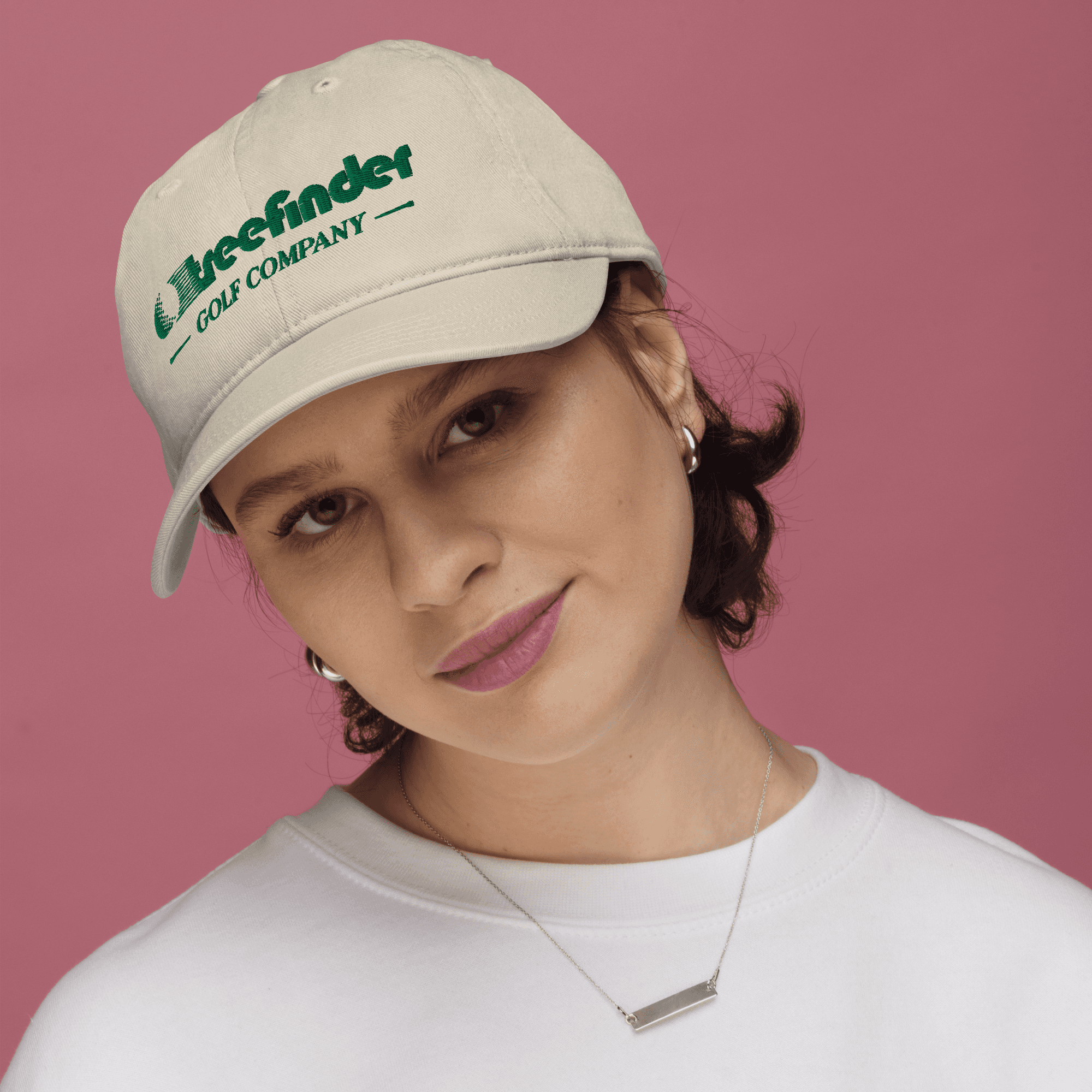 Graphic design mockup of women wearing golf hat for Treefinder Golf Company — bold, wordmark style logo with decorative sans serif typography, designed by Will Lefkovich.