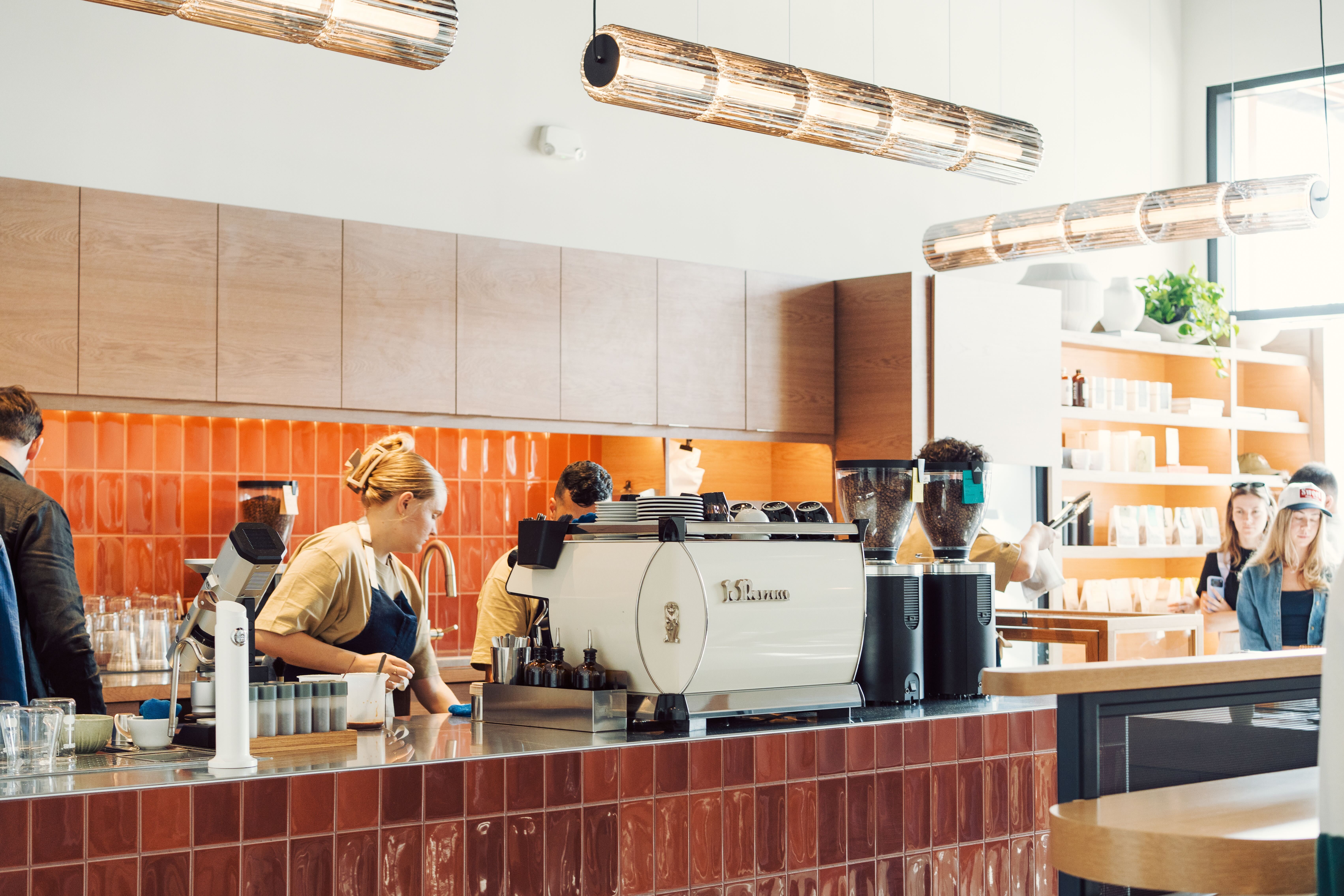 A minimalist cafe countertop with a floral arrangement in soft lighting.