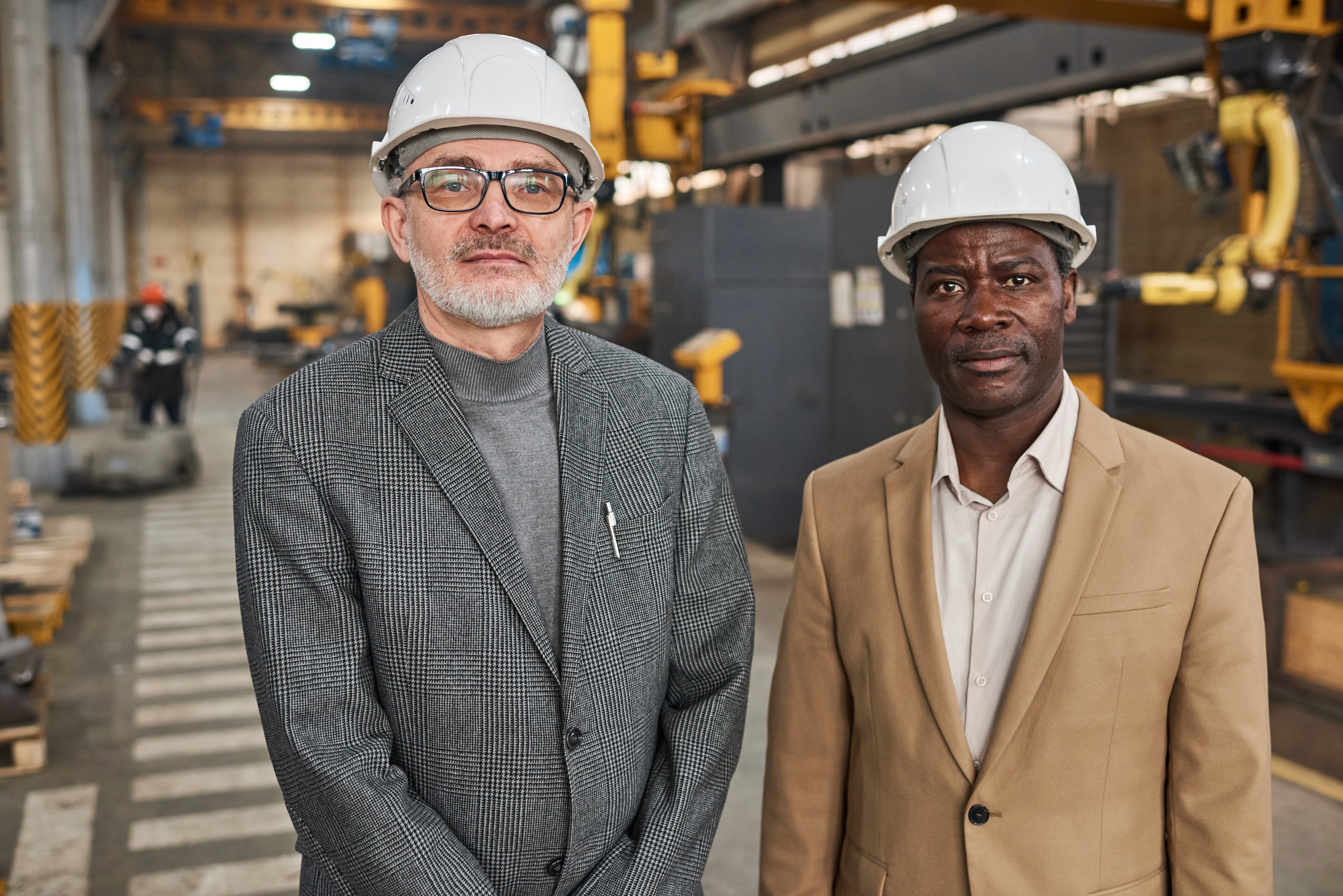 Dois profissionais em uma area de construcao trabalhando.