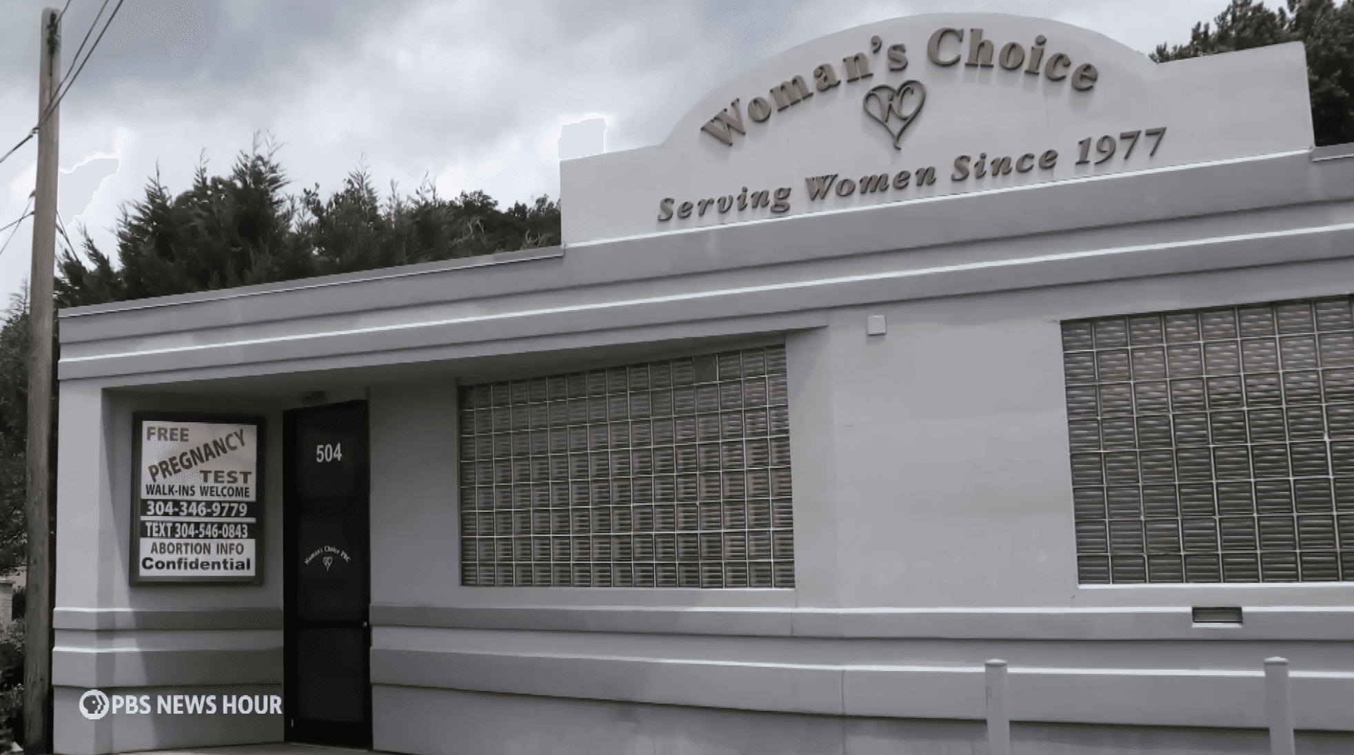 woman in black half-sleeved shirt sitting while facing woman and smiling