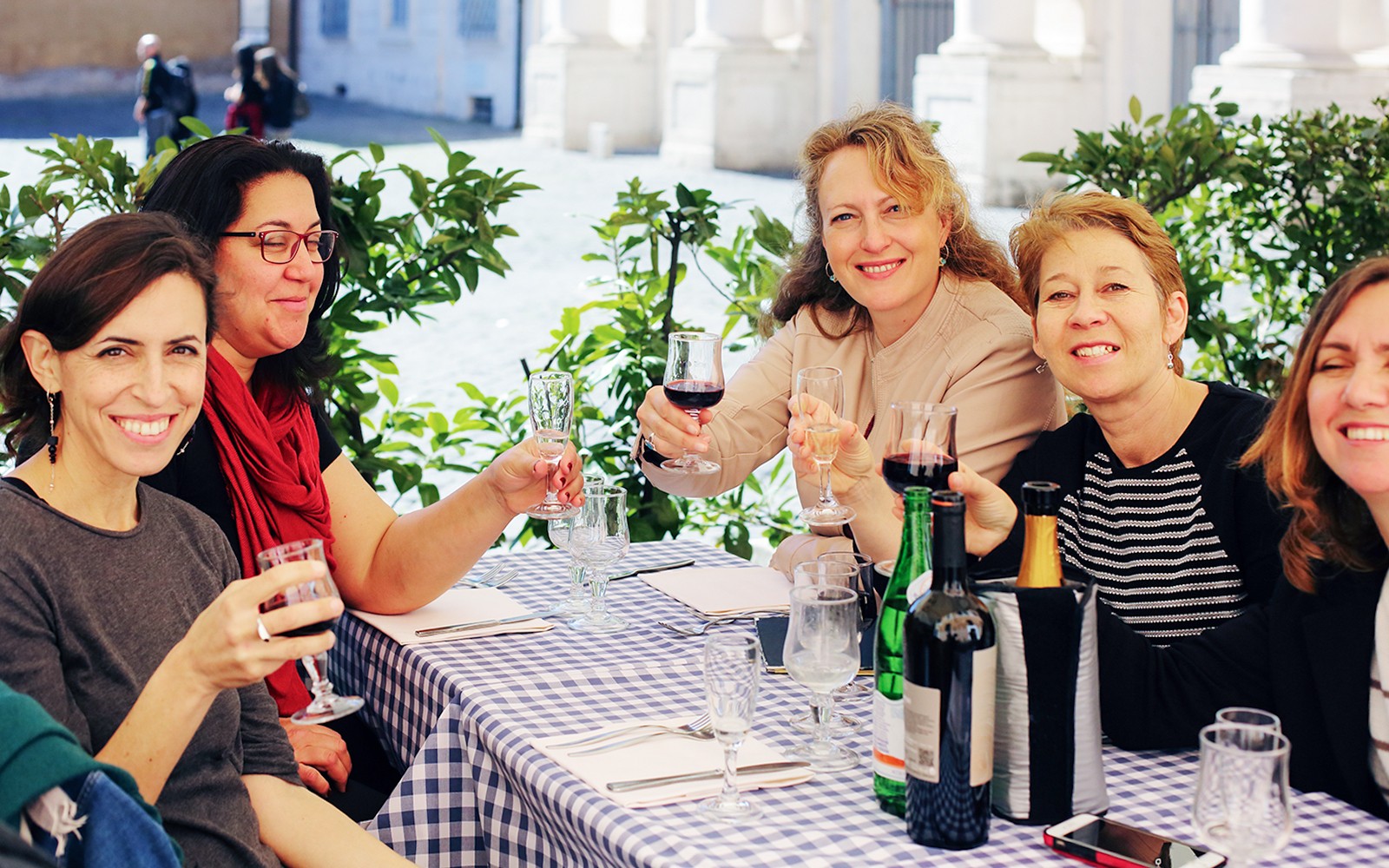 Friends enjoying wine at an outdoor cafe in Rome.